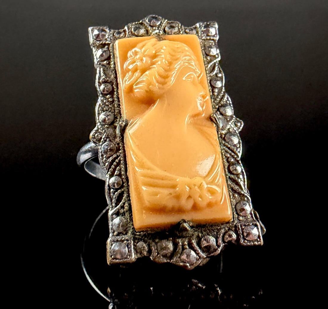 Uncas Art Deco Style Shell Cameo and Marcasite Ring: A vintage cocktail ring manufactured by the Uncas Manufacturing Company of Providence, Rhode Island. The ring features a rectangular face set with a carved shell cameo depicting a woman in profile wit