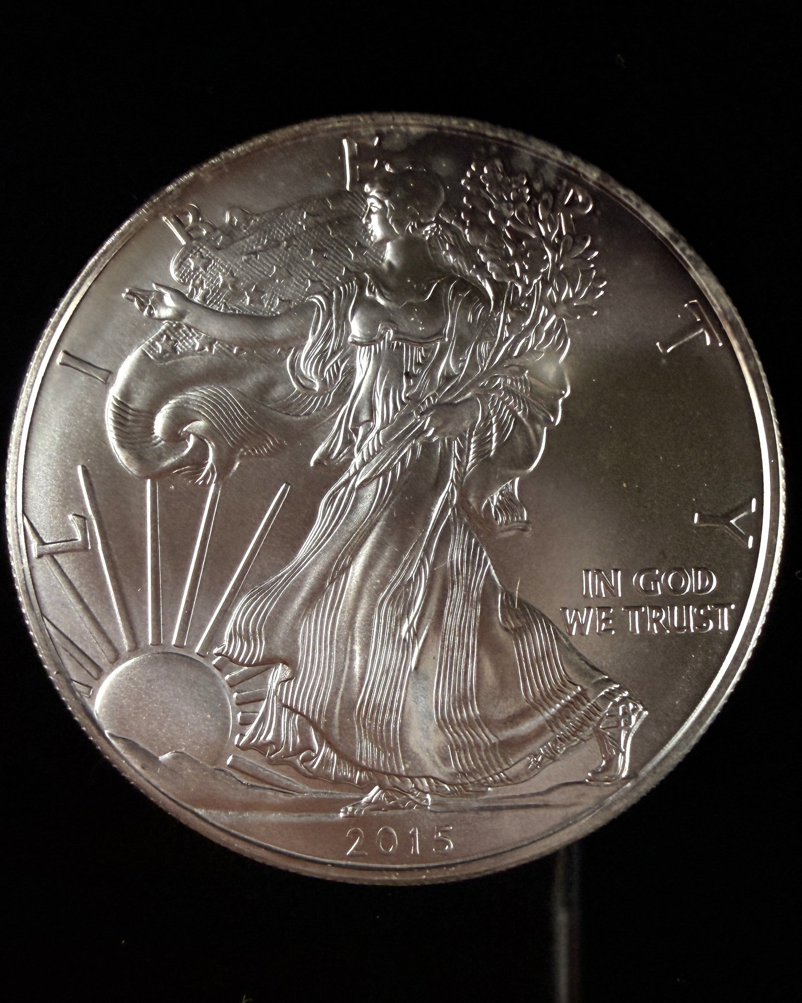 US 2015 American Silver Eagle 1 Dollar Bullion Coin: A 2015 American Silver Eagle 1 dollar bullion coin issued by the US Mint. The piece is struck in .999 fine silver and features the Walking Liberty obverse design. Visible inscriptions include LIBERTY 