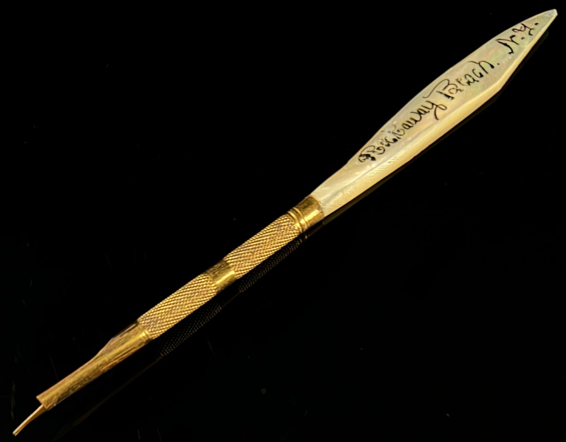 Victorian Mother-of-Pearl and Gold-Filled Souvenir Pen, Rockaway Beach, N.Y.: This late 19th-century Victorian writing instrument featuring a carved mother-of-pearl handle and a gold-colored metal barrel. The handle is tapered with flat sides. One side is hand-inscribed with