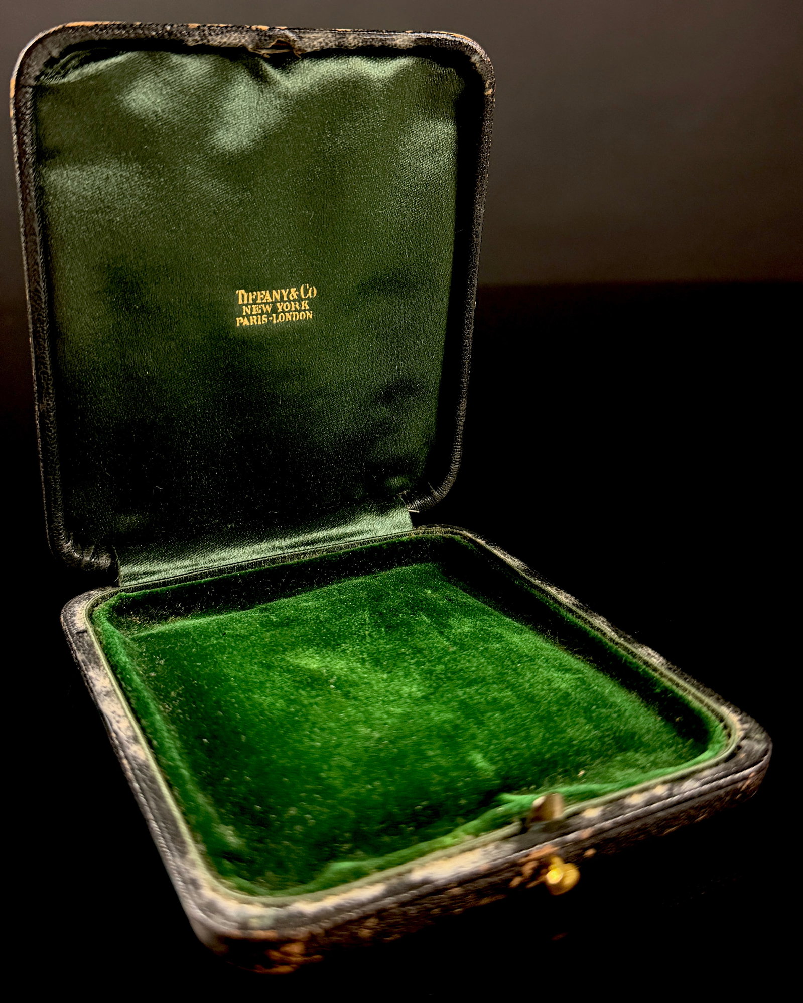 Early 20th Century Tiffany & Co. Leather Presentation Case: This antique presentation case was produced by Tiffany & Co. for the containment of a medal, large jewelry piece, or high-end desk accessory. The exterior is finished in a black pebble-grained