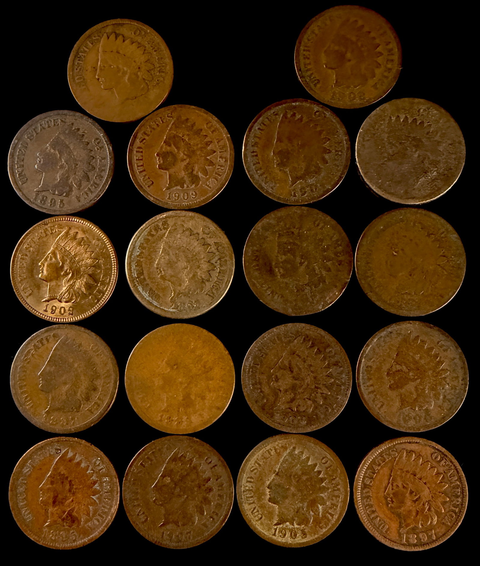 A Lot of 18 US Indian Head Cents: This lot of 18 US bronze one-cent coins features the Indian Head design series. The obverse of each coin depicts Liberty in a headdress, while the reverse features a wreath and shield design. The coll