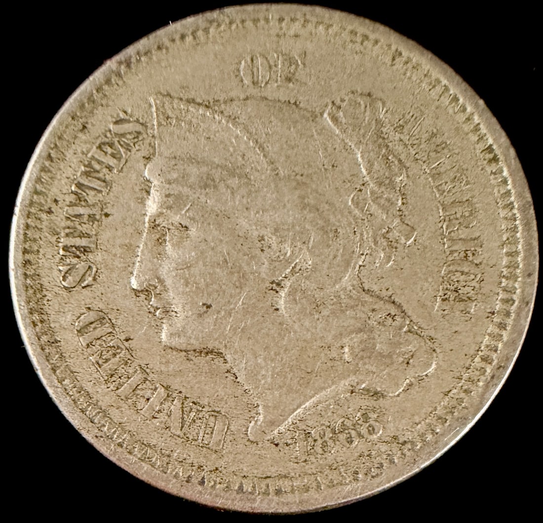 US 1868 Three-Cent Nickel Coin: United States Three-Cent Nickel coin dated 1868. Struck in a copper-nickel alloy at the Philadelphia Mint. This specimen features the Liberty head obverse and the Roman numeral III reverse within a