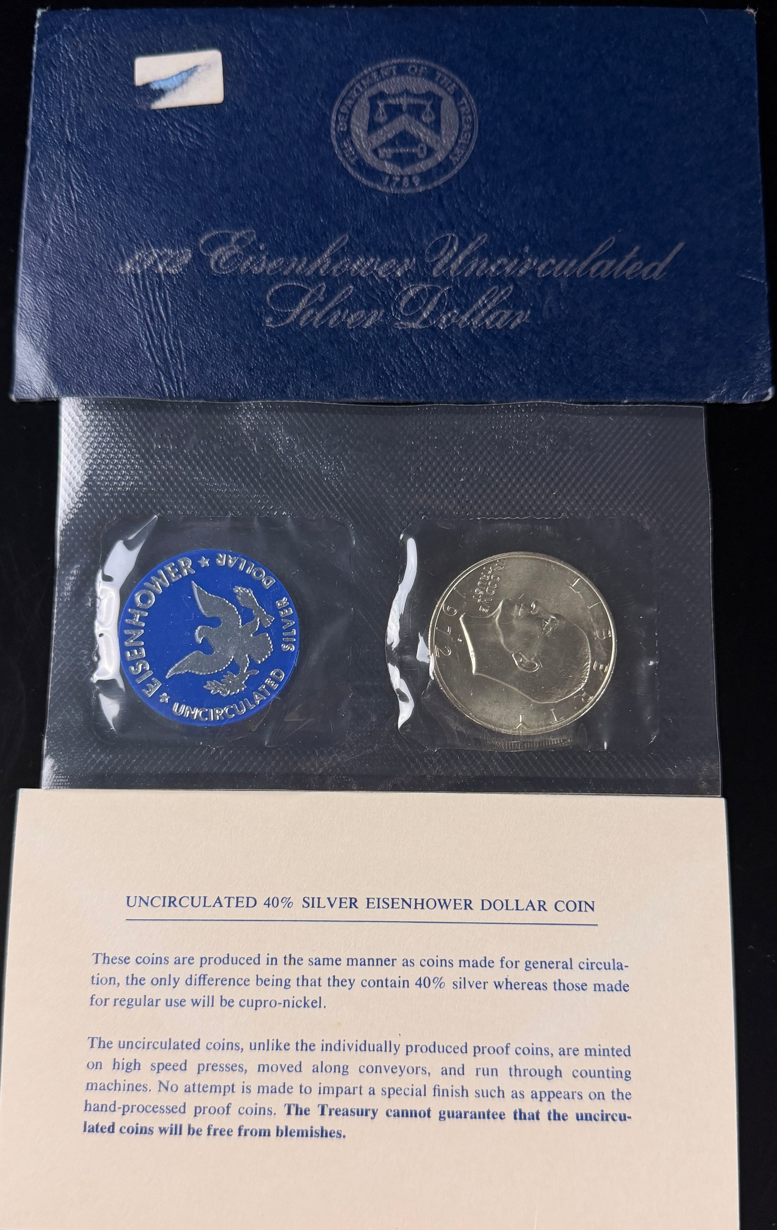 1972-S US Eisenhower Silver Dollar Uncirculated 40% Silver Blue Envelope Set: A 1972-S US Eisenhower silver dollar struck at the San Francisco Mint (KM# 203a). This coin features the Eisenhower obverse and Apollo 11 reverse designs. It is composed of 40% silver and was issued