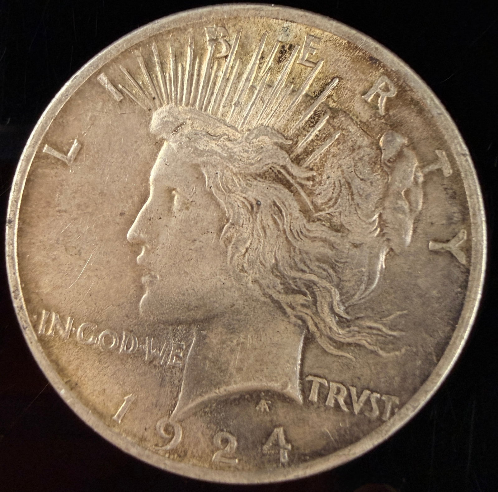 1924 US Peace Silver Dollar: 1924 US Peace silver dollar struck at the Philadelphia Mint. This specimen is composed of 0.900 silver and 0.100 copper. The coin features the Peace Dollar obverse design by Anthony de Francisci, with