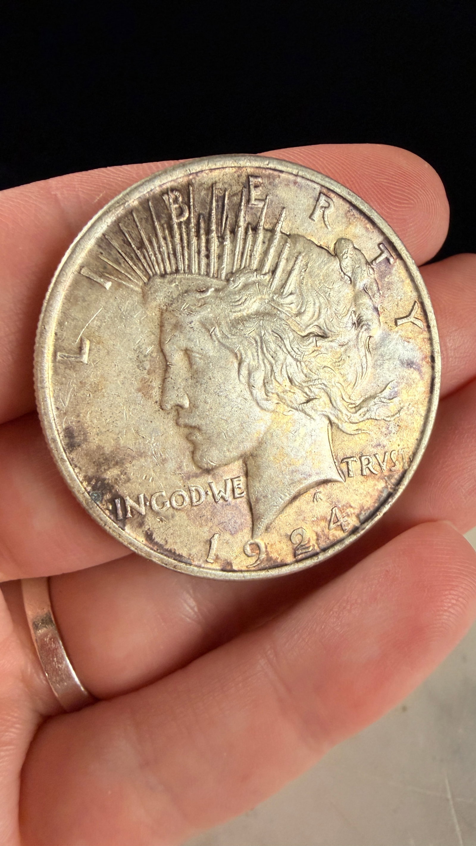 1924 US Peace Silver Dollar: 1924 US Peace silver dollar struck at the Philadelphia Mint. This coin is composed of 90 percent silver and 10 percent copper. It features the standard Peace Dollar design by Anthony de Francisci and 