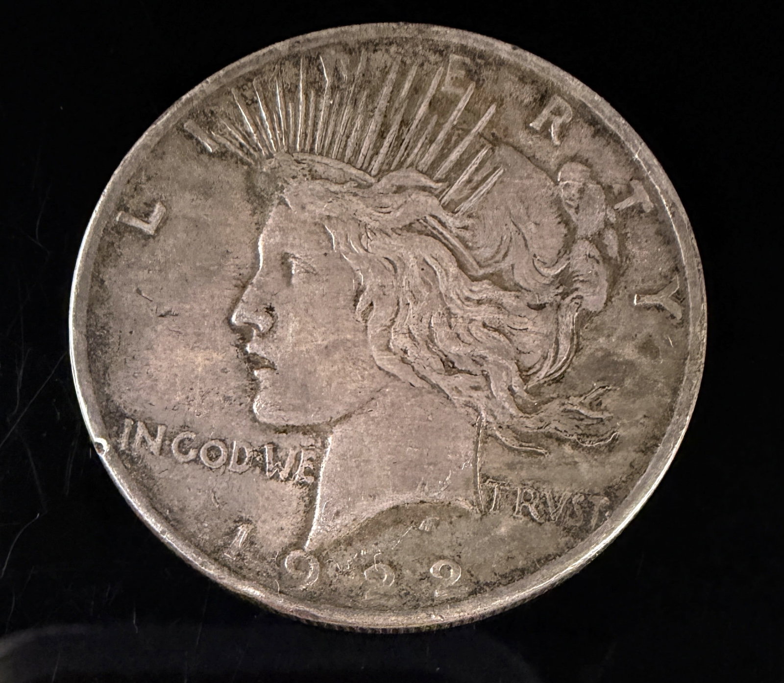 1922 US Peace Silver Dollar: This 1922 US silver Peace dollar was struck at the Philadelphia Mint. The coin is composed of 90 percent silver and 10 percent copper. The design features the standard Peace dollar obverse and