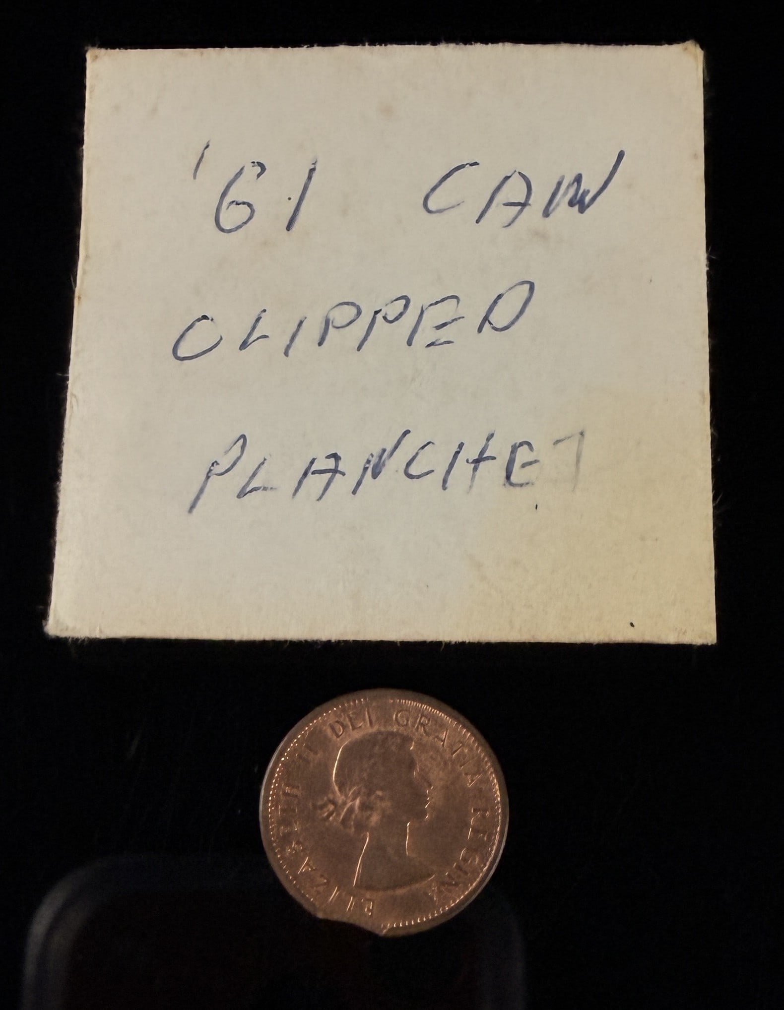 1961 CA One Cent, Clipped Planchet Error: A 1961 Canadian one-cent coin struck in copper featuring a significant clipped planchet error. The obverse displays the Elizabeth II laureate head design. The reverse features the Maple Leaf design