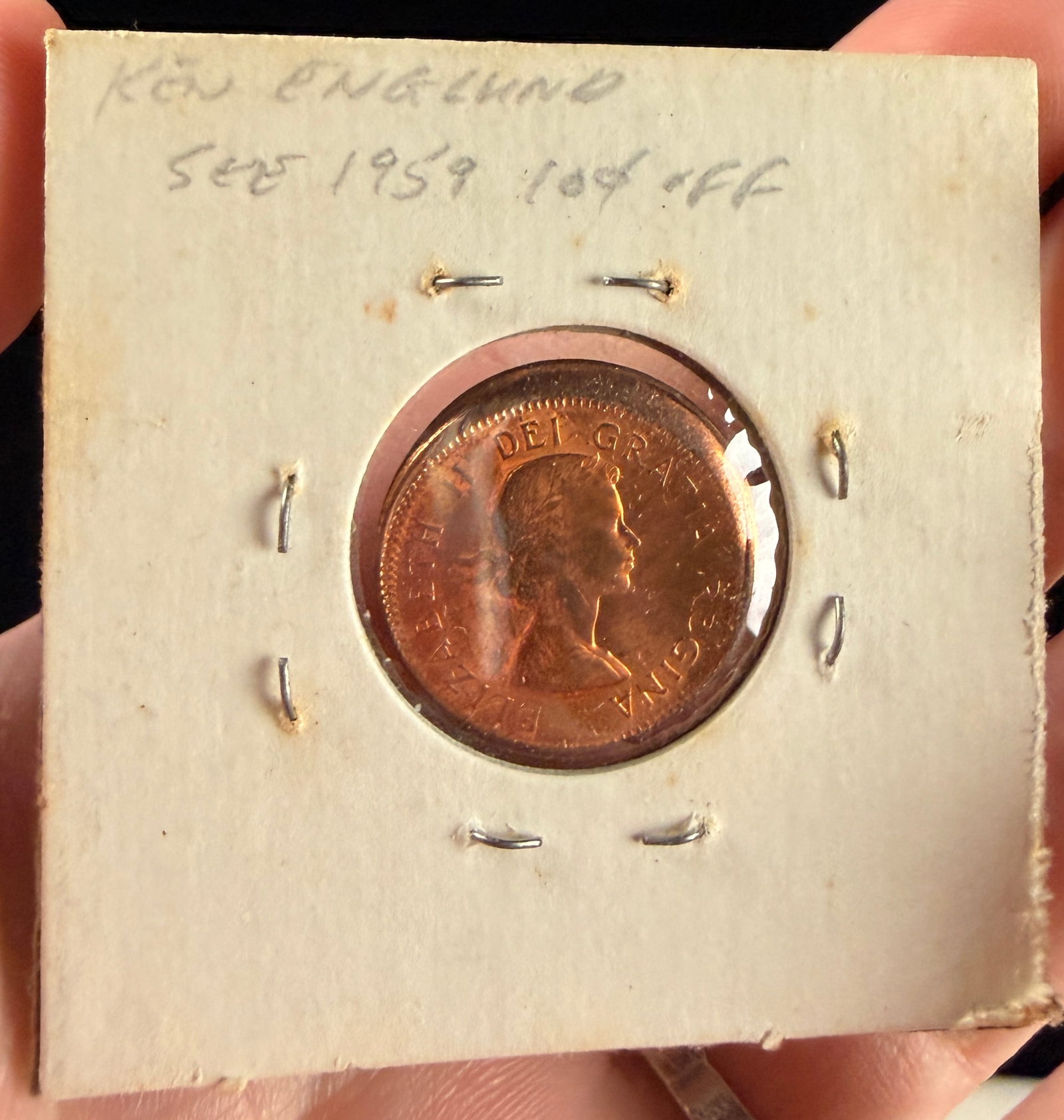 Canada 1961 1 Cent Bronze Coin with Off-Center Strike Error: A Canada 1961 1 cent bronze coin, cataloged as KM# 59. The obverse features the laureate bust of Queen Elizabeth II, while the reverse depicts two maple leaves on a twig, a design by G.E. Kruger-Gray.