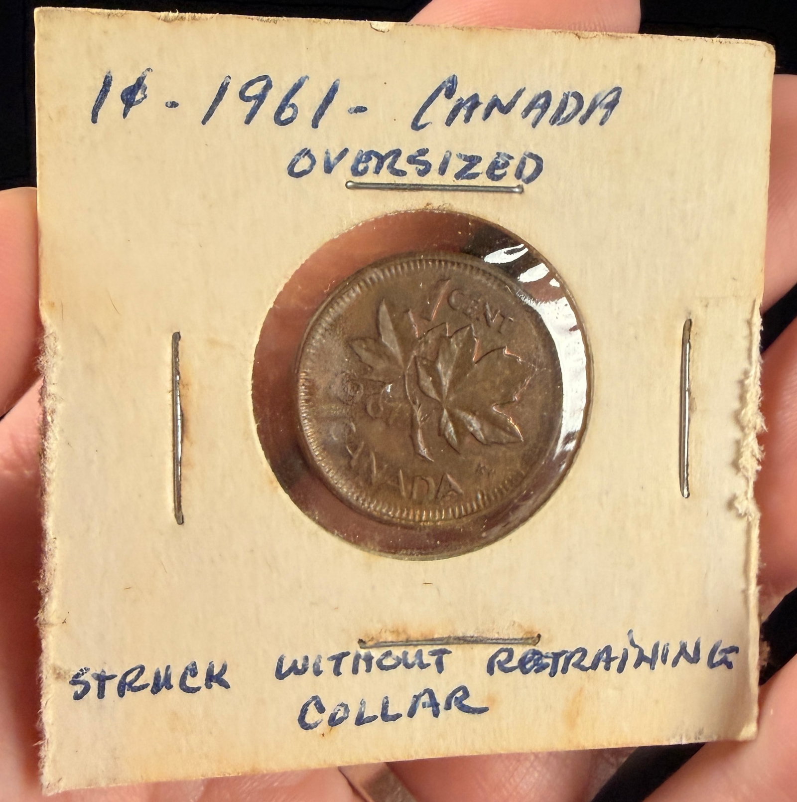 1961 CA 1 Cent Broadstruck Mint Error: A 1961 Canadian 1-cent bronze coin struck without a restraining collar, a mint error known as a broadstrike. The absence of the collar during the striking process allowed the planchet to expand
