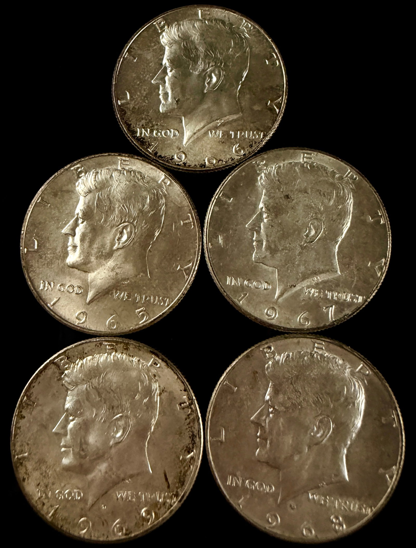 A Group of US Kennedy Half Dollars, 1965-1969: This group of US Kennedy Half Dollars contains specimens dated 1965, 1966, 1967, 1968, and 1969. The 1968 and 1969 coins feature the D mint mark representing the Denver Mint, while the 1965, 1966, and