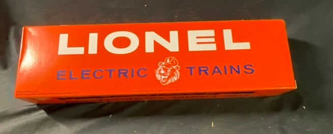 Lionel L.L.C. No. 6819 Flat Car with Helicopter in Original Box: This item is a 2012 modern reissue of the classic postwar No. 6819 Flat Car with Helicopter, produced by Lionel L.L.C. The model is housed in its original orange and blue cardboard box, designed in th