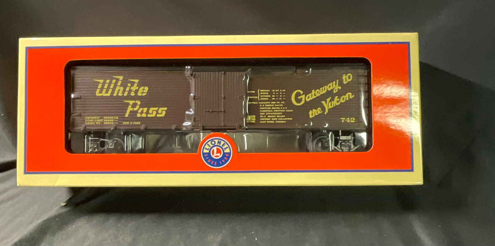 Lionel O-Gauge 6-19579 White Pass and Yukon Route Reefer Car: Lionel L.L.C. O-Gauge model railroad refrigerator car, model number 6-19579, featuring the White Pass and Yukon Route livery. The car is constructed with a brown wood-grain textured plastic body and y