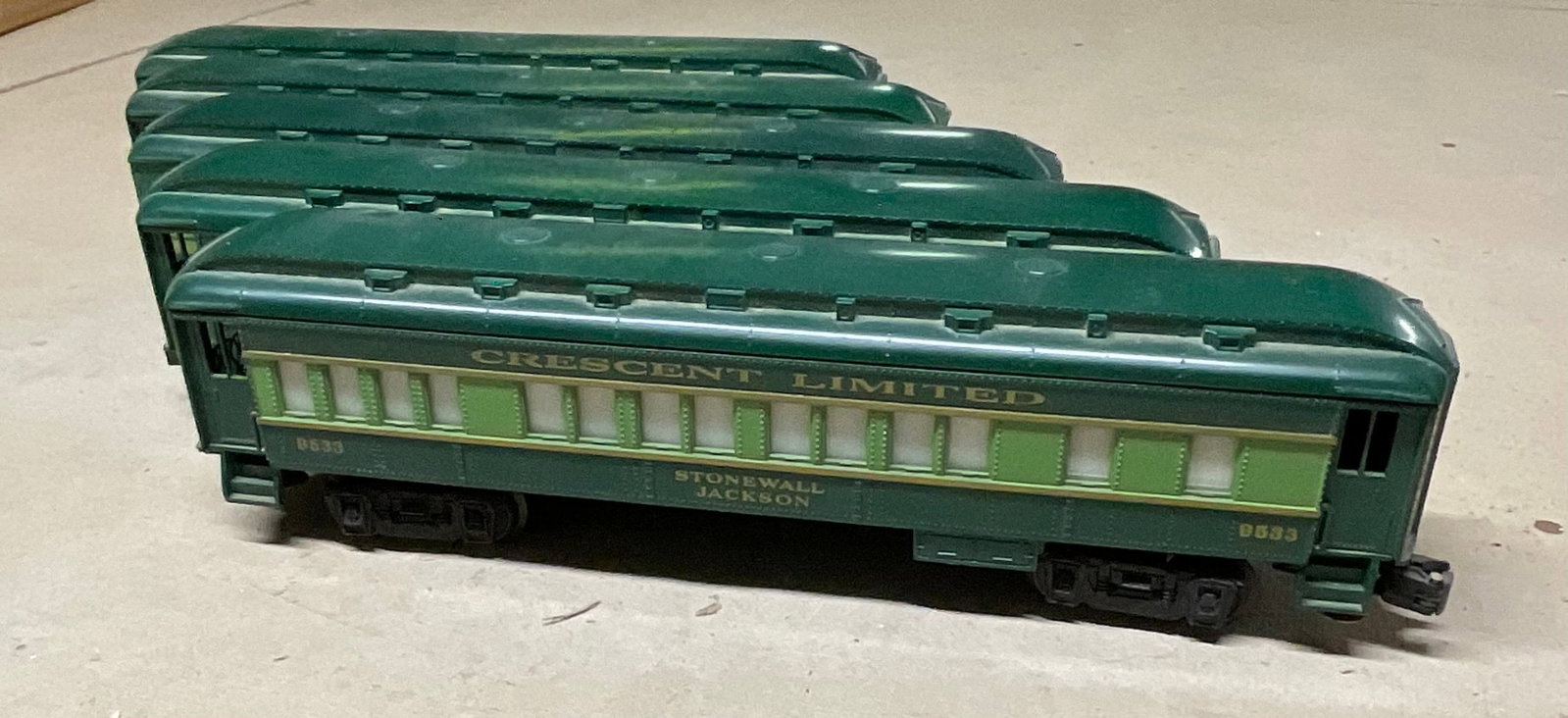 A Collection of Lionel Southern Crescent Limited O-Gauge Passenger Cars: A collection of O-gauge model train passenger cars manufactured by Lionel, featuring the Southern Railway Crescent Limited livery. The cars are finished in a two-tone green color scheme with gold-tone