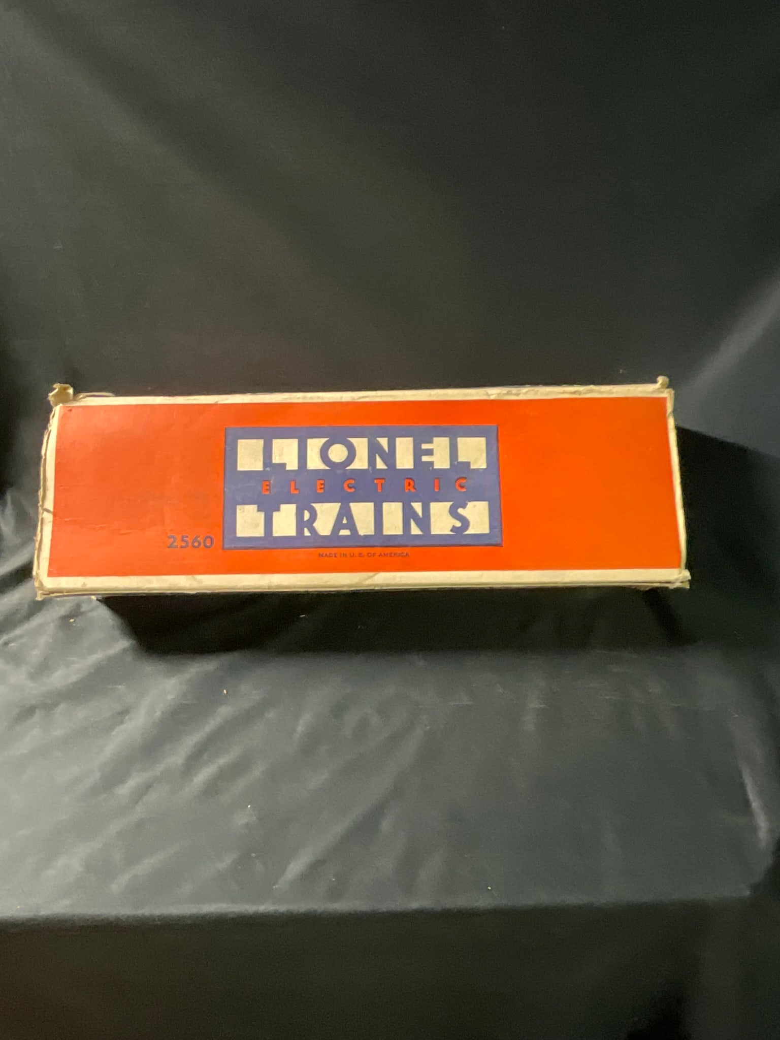 Lionel Corporation Model 2560 O Gauge Crane Car with Original Box: A vintage O gauge model train crane car, model number 2560, manufactured by The Lionel Corporation. The piece features a die-cast metal frame base with a painted cab and boom. The cab is designed to r