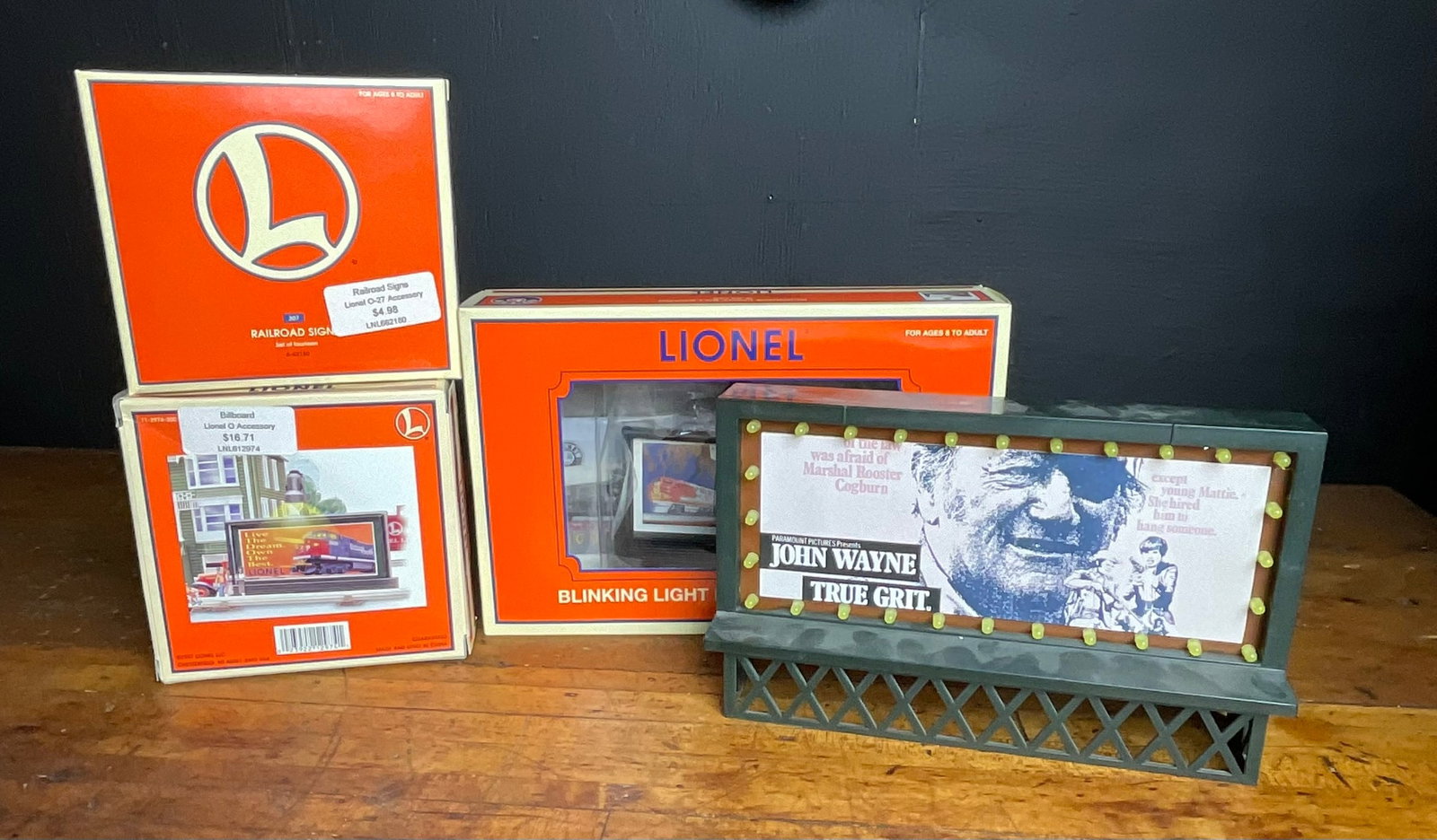 A Group of Lionel O and O-27 Scale Model Railroad Accessories: This lot contains model railroad accessories manufactured by Lionel LLC, primarily constructed of molded plastic. The group includes three items in their original packaging and one loose accessory. Th