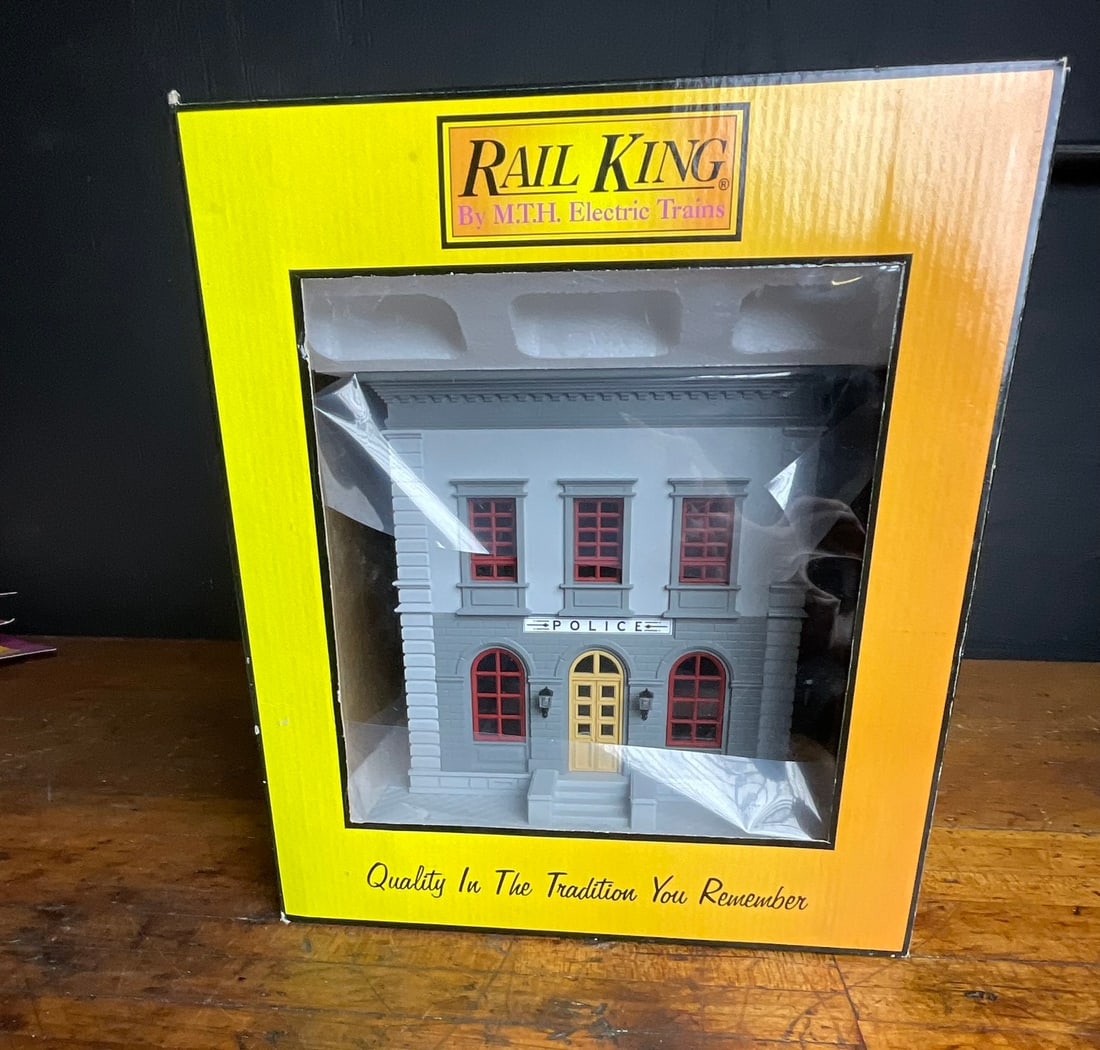 M.T.H. Electric Trains RailKing O-Scale Police Station Model Building 30-9099: This model railroad accessory is an O-Scale structure produced by M.T.H. Electric Trains as part of their RailKing line. The item, designated as Item No. 30-9099, is a fully assembled model of a two-s