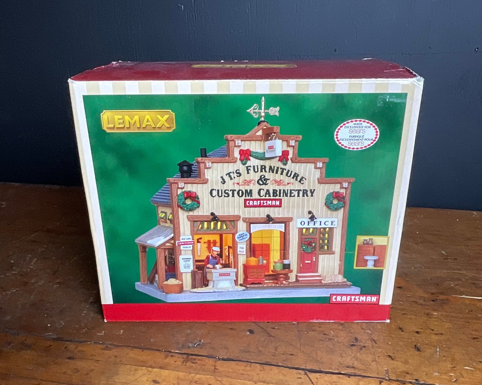Lemax 25421 J.T.'s Furniture & Custom Cabinetry Sears Exclusive Lighted Building with Box: A collectible miniature lighted building produced by Lemax as an exclusive for Sears. This piece, item number 25421, is titled J.T.'s Furniture & Custom Cabinetry and features prominent branding for C