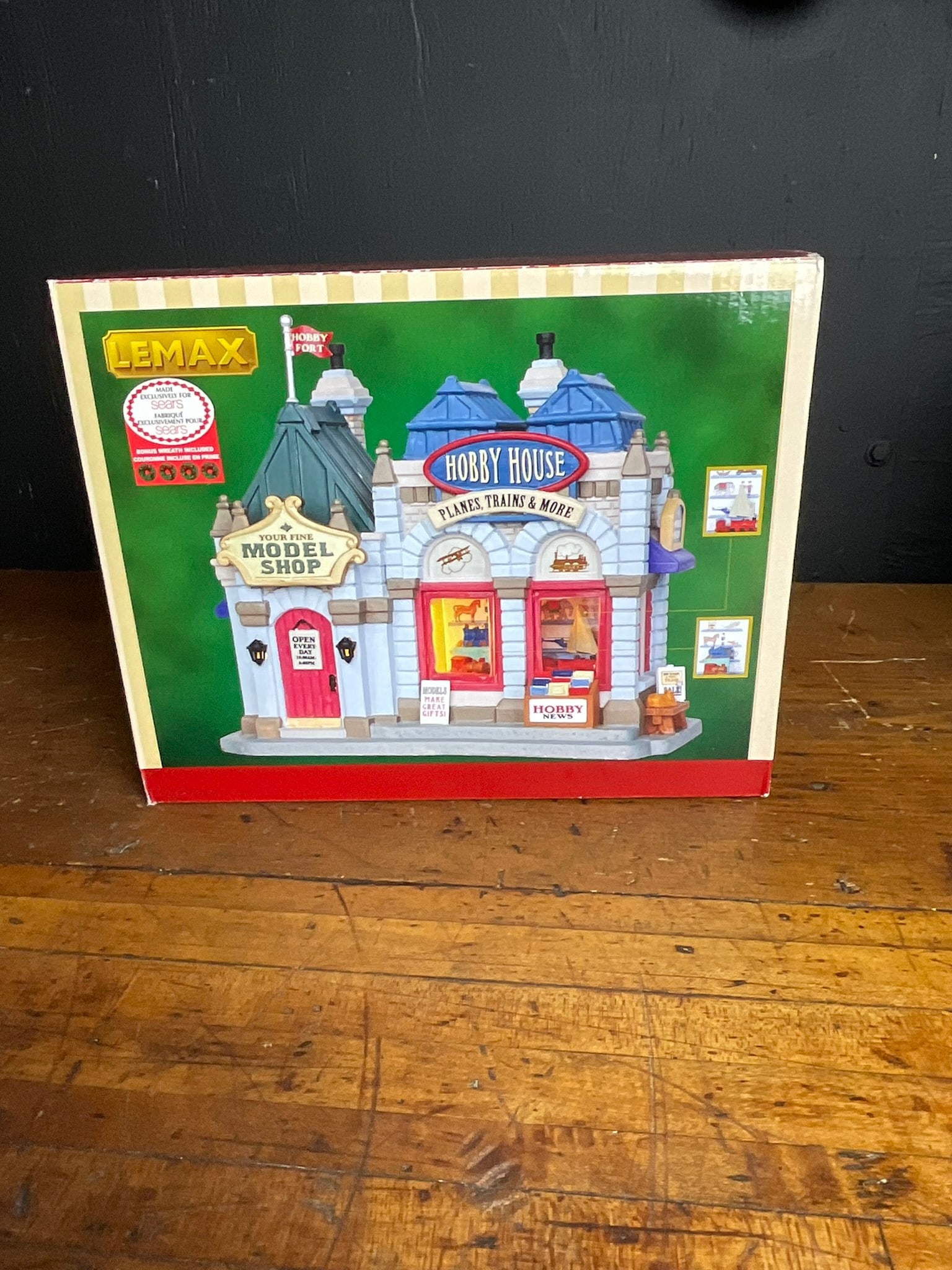 Lemax #25419 Hobby House and Model Shop Lighted Building Sears Exclusive Edition: A Lemax lighted building collectible titled Hobby House / Your Fine Model Shop, model number 25419. This piece was produced as a Sears Exclusive Edition, as noted by the original retail sticker on the