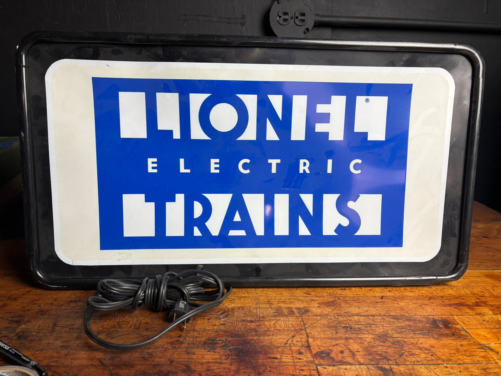 TecArt Industries Lionel Electric Trains Lighted Advertising Sign: A contemporary lighted display sign for Lionel Electric Trains, manufactured by TecArt Industries, Inc. The sign features a translucent plastic front panel with the Lionel brand logo, displaying the t