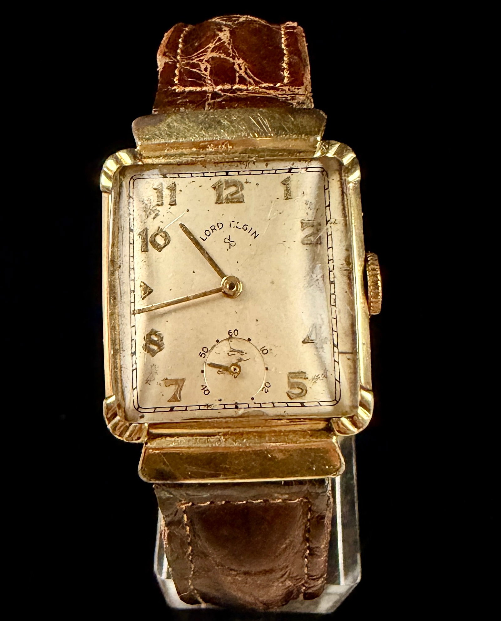 Lord Elgin 14K Gold Filled Rectangular Tank Watch with Hooded Lugs and Omega Band: A vintage manual wind wristwatch by the Elgin National Watch Company from the Lord Elgin flagship line, produced circa 1940s-1950s. The timepiece features a rectangular tank-style 14K gold filled case