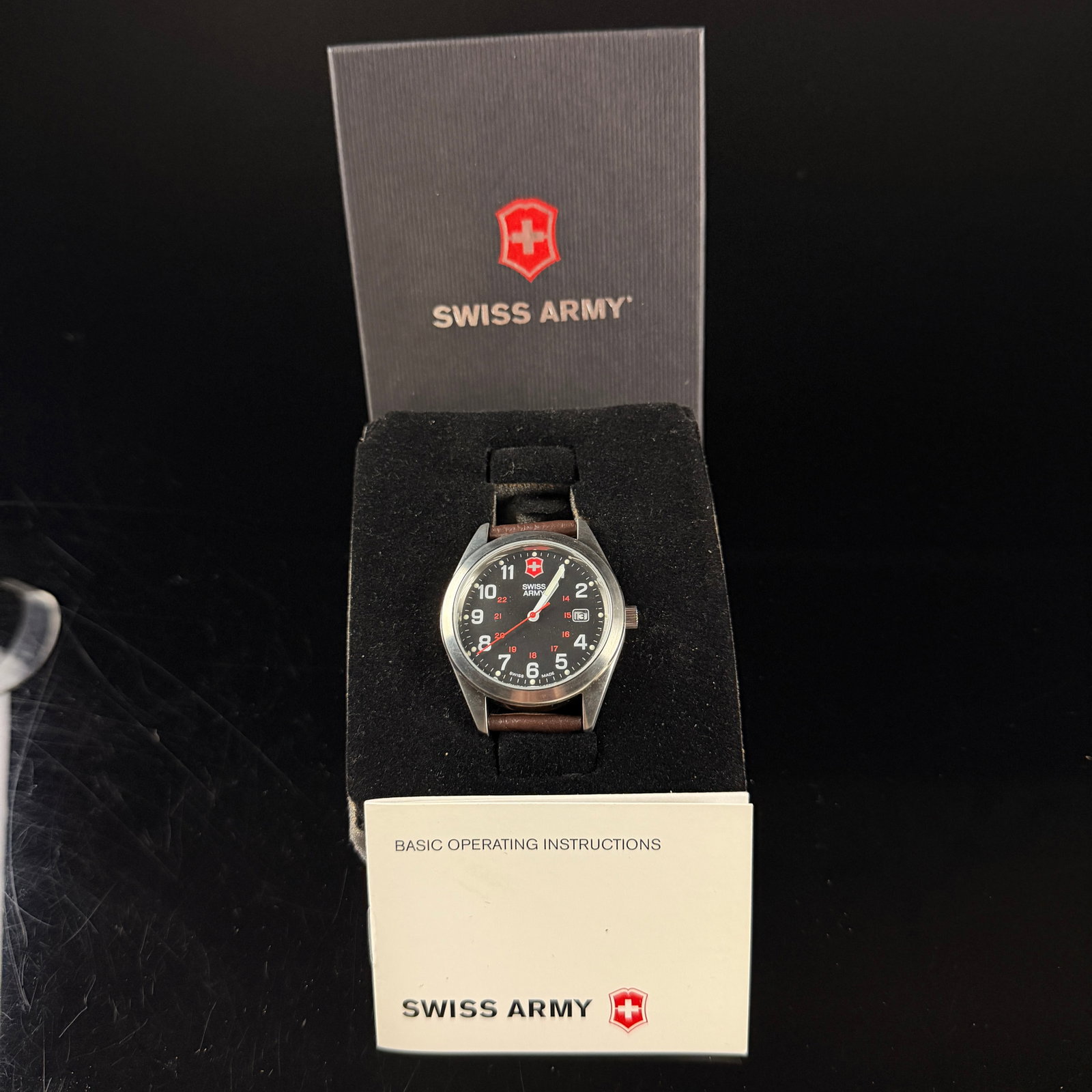 Victorinox Swiss Army Field Watch INC-87420 New Old Stock in Box: This is a Victorinox Swiss Army quartz wristwatch, identified as a Field Watch (Large) on the original packaging. The watch features a brushed stainless steel case with a screw-down case back and a te