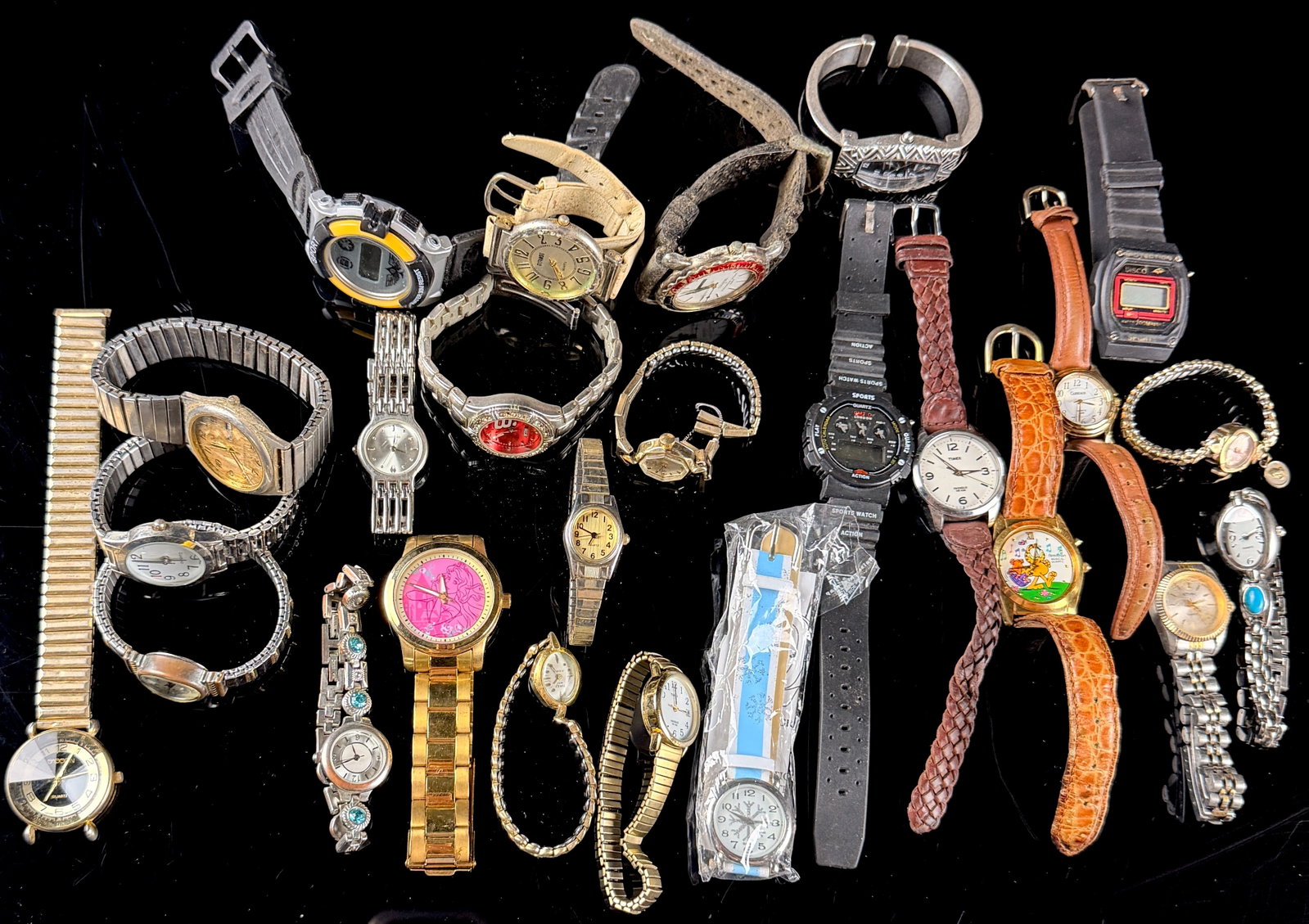 An Assortment of Twenty-Two Miscellaneous Wristwatches Including Timex, Armitron, and Gitano: An assortment of twenty-two miscellaneous wristwatches in various styles and materials. The lot features several recognizable brands including Timex, Armitron, Gitano, Spoon, Alexander Julian, Carriag