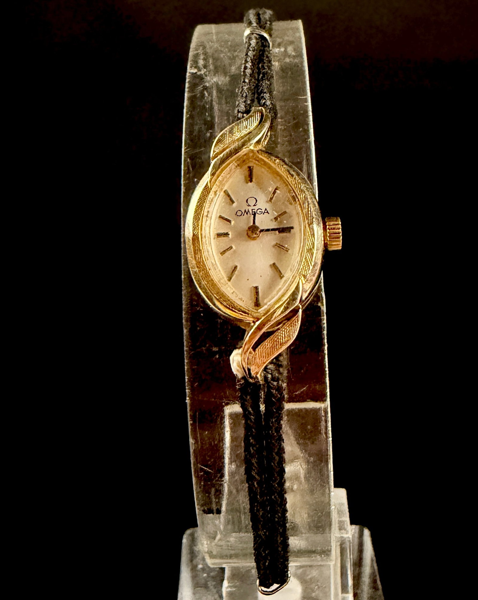 Vintage Omega 14K Yellow Gold Ladies Manual Wind Cocktail Watch, Runs: A vintage ladies Omega dress watch featuring a solid 14 karat yellow gold case in a marquise-style oval shape. The case is designed with decorative textured leaf-motif lugs. It features a champagne-to