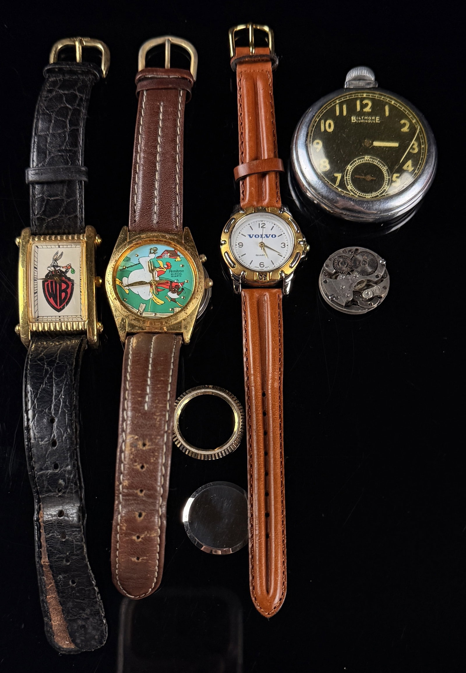 An Assortment of Vintage Character Promotional and Mechanical Watches: A collection featuring character and promotional wristwatches along with mechanical timepieces. The group includes a Warner Bros. Watch Collection Bugs Bunny rectangular wristwatch with a gold-toned c