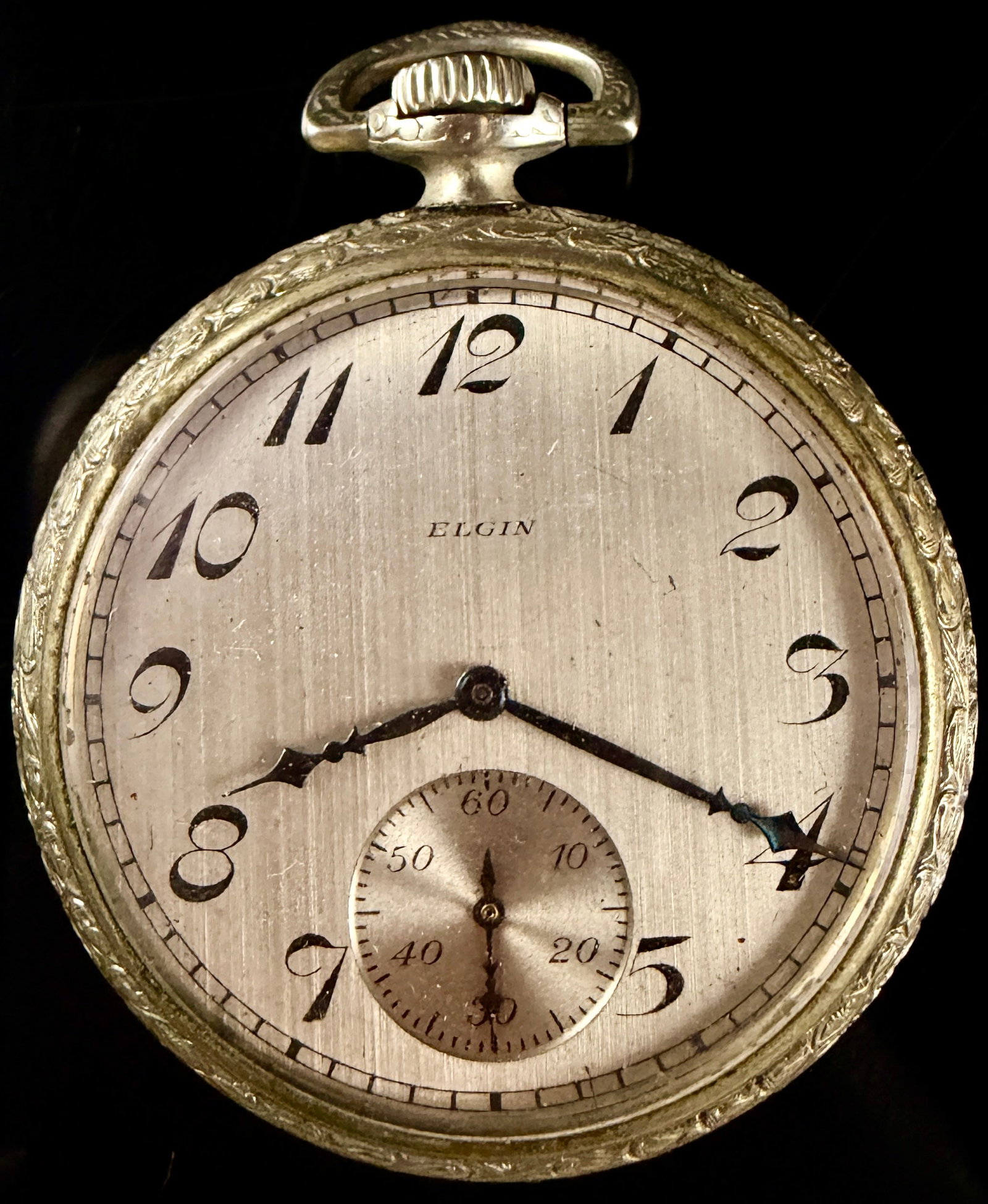 Elgin National Watch Co. Art Deco Engraved Nickel Open Face Pocket Watch: This Art Deco era open-face pocket watch was manufactured by the Elgin National Watch Co. and features a nickel case produced by the Illinois Watch Case Co. The silver-tone dial is finished with a ver