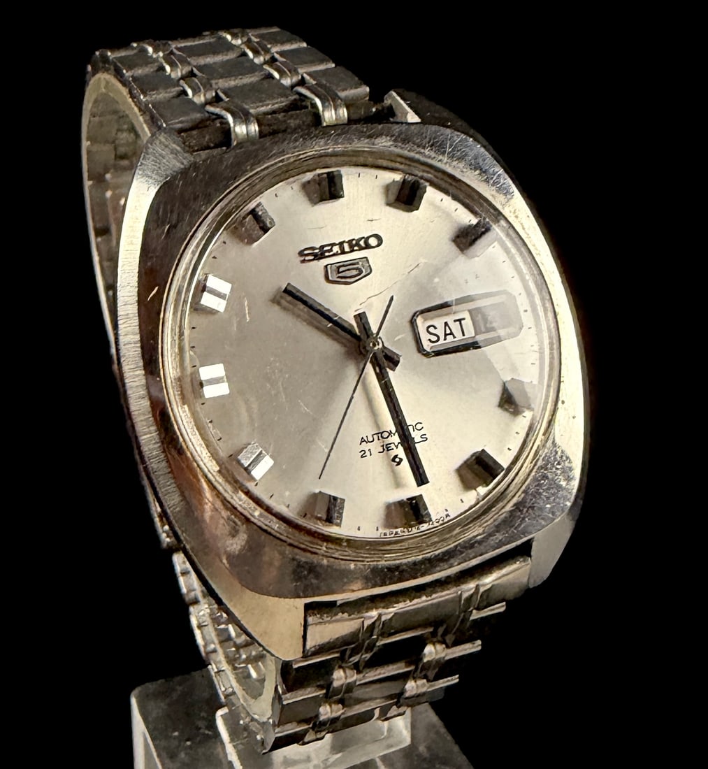 Vintage Seiko 5 Automatic 6119-7103 Stainless Steel Wristwatch November 1970 Runs: Seiko 5 Automatic wristwatch, reference 6119-7103, produced in November 1970. The timepiece features a stainless steel cushion-shaped case with a matching multi-row link bracelet and folding clasp. Th