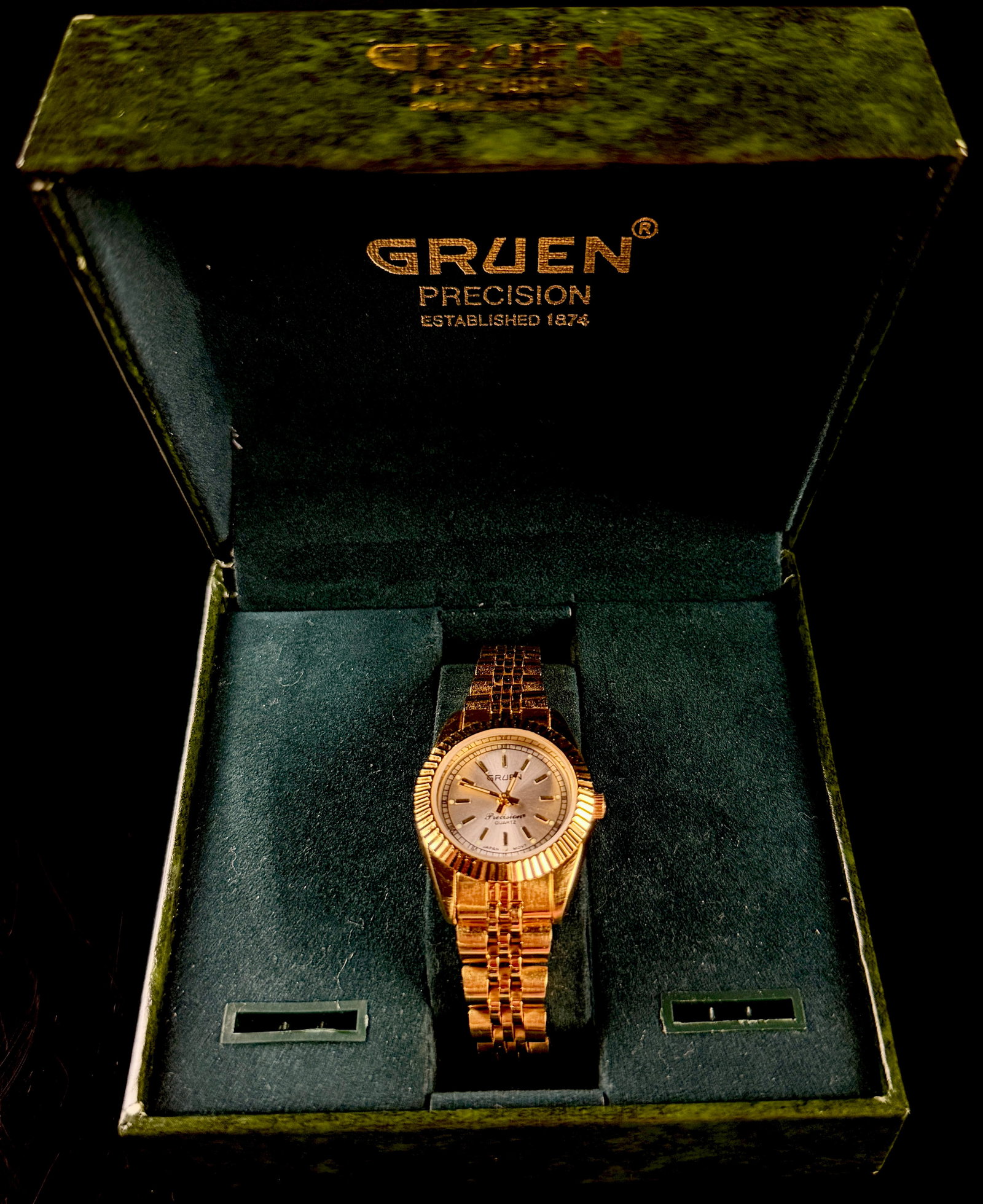 New Old Stock Ladies Gruen Precision Quartz Wristwatch Reference GP3000 with Box: A ladies Gruen Precision quartz wristwatch, reference GP3000. This new old stock timepiece features a gold-tone base metal case with a fluted bezel and a stainless steel case back. The silver-tone sun