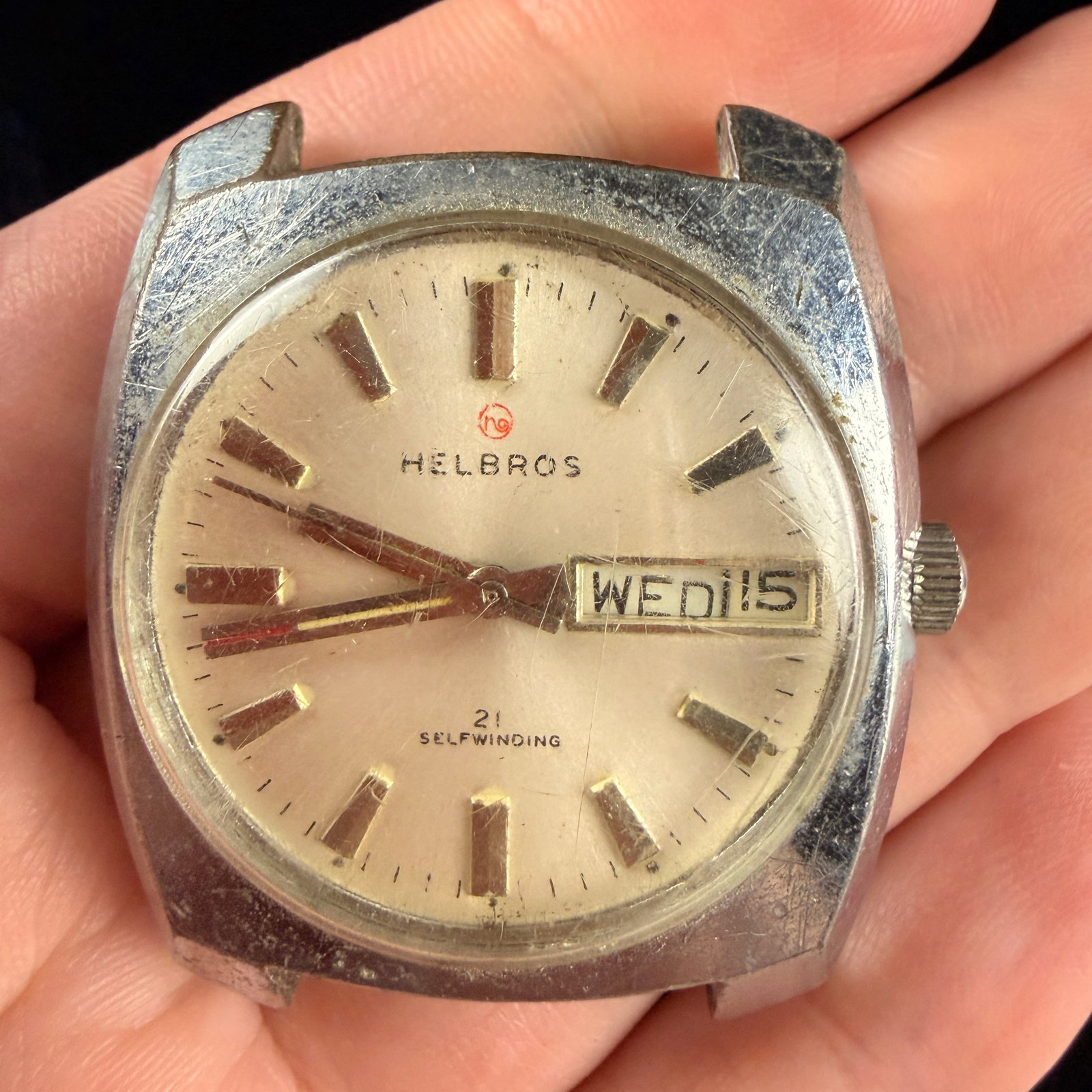 Helbros 21 Jewel Self-Winding Day-Date Wristwatch Head: A vintage Helbros men's wristwatch head featuring a 21-jewel self-winding automatic movement. The silver-tone sunburst dial displays applied faceted hour indices and a day-date aperture located at the