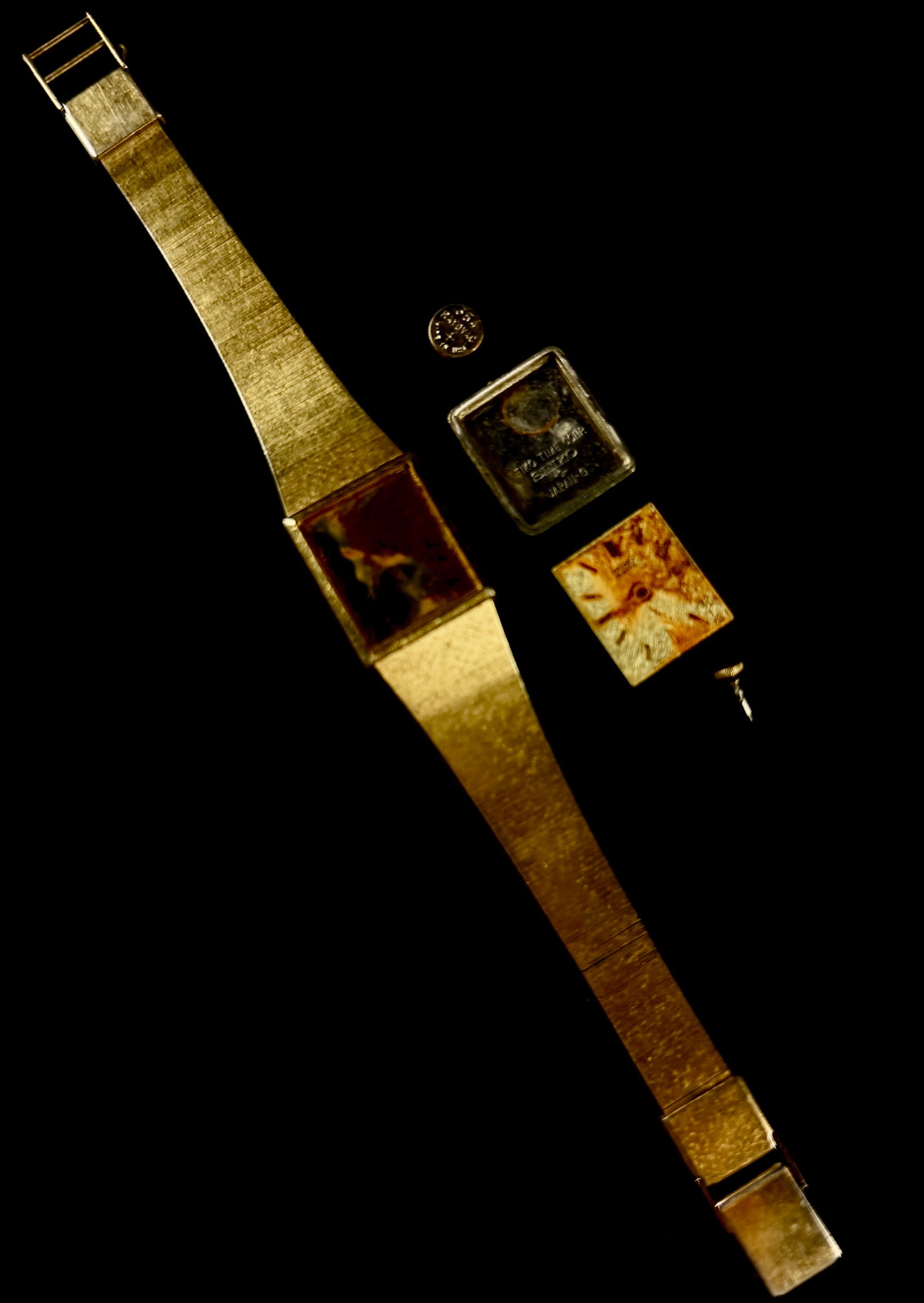 Seiko Quartz Caliber 1421 Ladies Dress Watch for Parts or Repair: A vintage Seiko quartz ladies dress watch featuring a square case and integrated textured bracelet. The watch is presented in a disassembled state and consists of the main case with bracelet, a separa