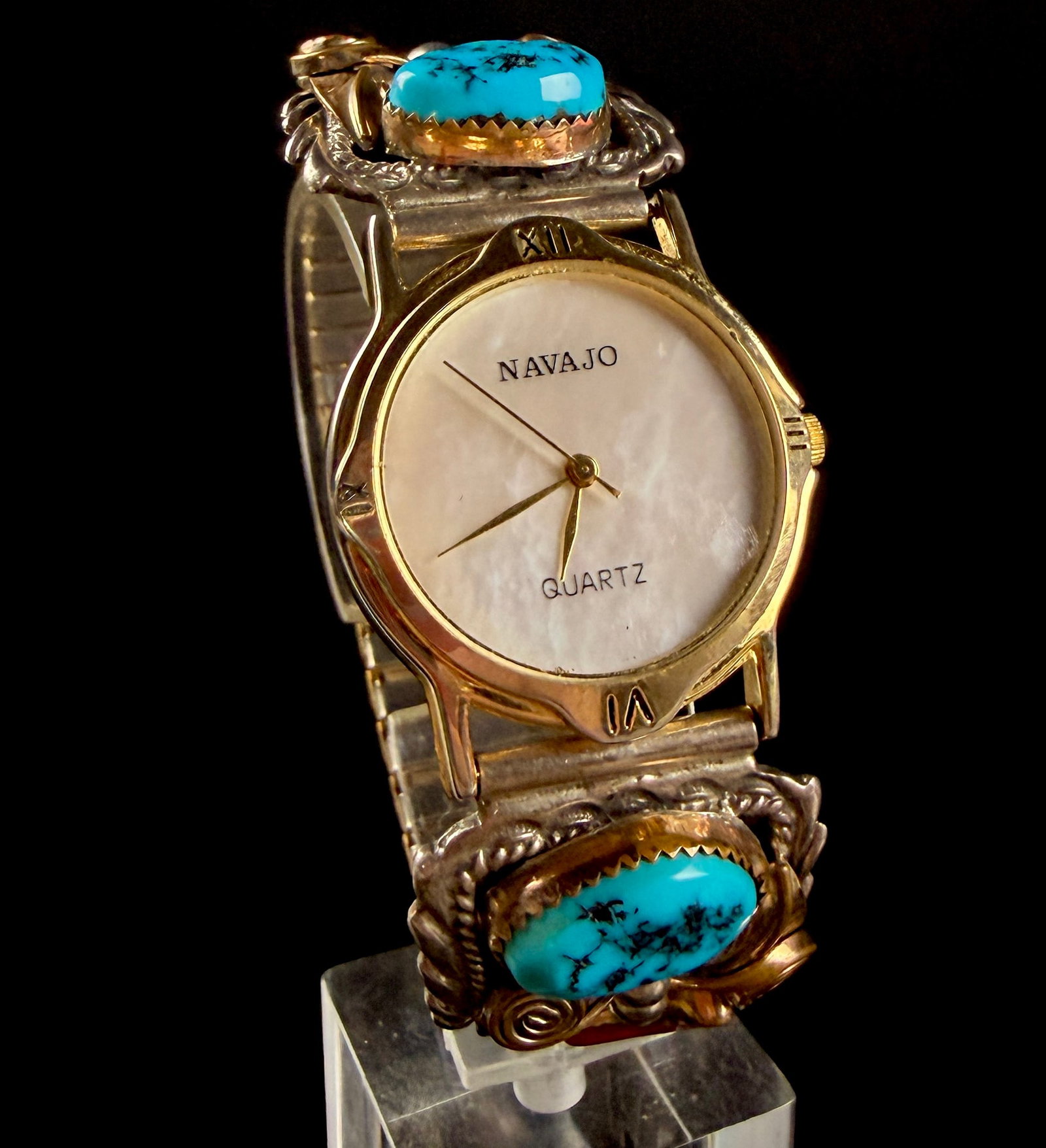 Navajo Gold-Tone Quartz Wristwatch with Sterling Silver Turquoise and Coral Watch Tips: Brand: Navajo Model: Not specified Reference Number: Not specified A Southwestern-style wristwatch featuring a gold-tone base metal case and a mother-of-pearl dial. The dial is marked Navajo and Quart