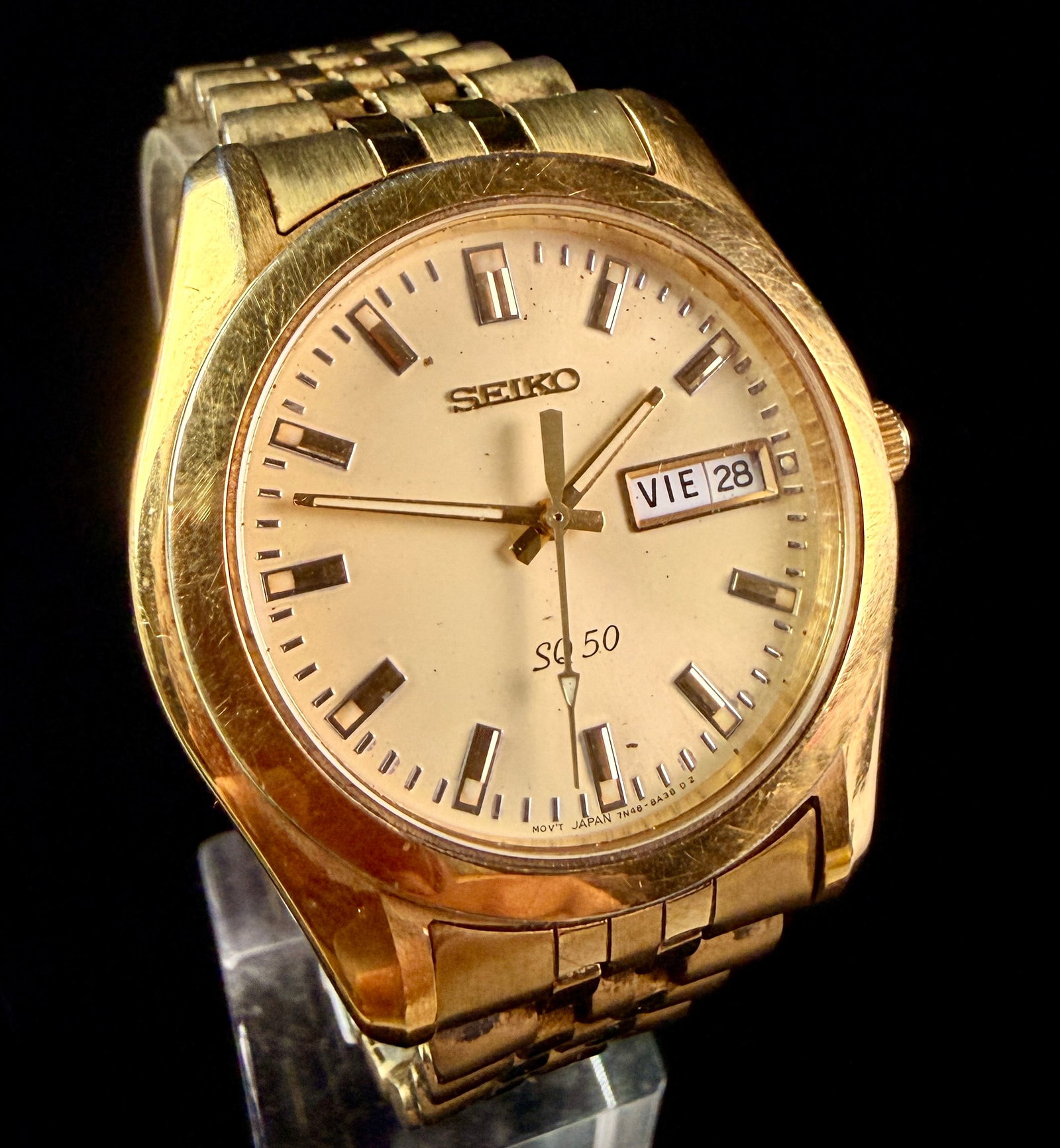 Vintage Seiko SQ 50 Gold-Tone Quartz Wristwatch Ref. 7N43-8A00: This vintage Seiko SQ 50 quartz wristwatch features a gold-tone base metal case with a matching jubilee-style bracelet. The champagne dial displays applied gold-tone baton hour markers, a minute track