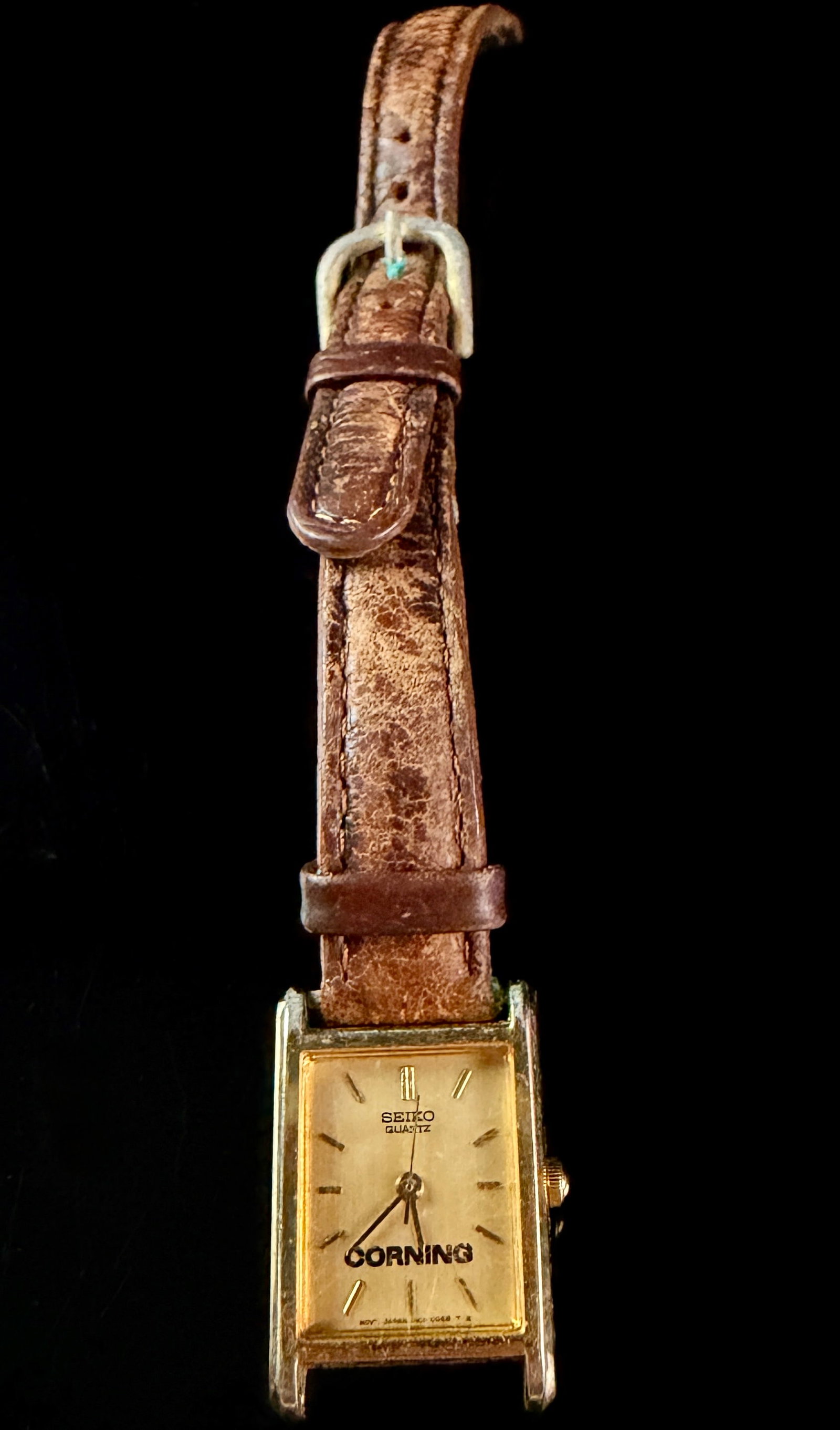 Seiko Women's Quartz Tank Style Corporate Edition Wristwatch 1N01-5A40: A vintage Seiko ladies' quartz wristwatch featuring a rectangular gold-tone case in the classic Tank style. This piece was produced as a corporate edition for Corning Incorporated, featuring the compa