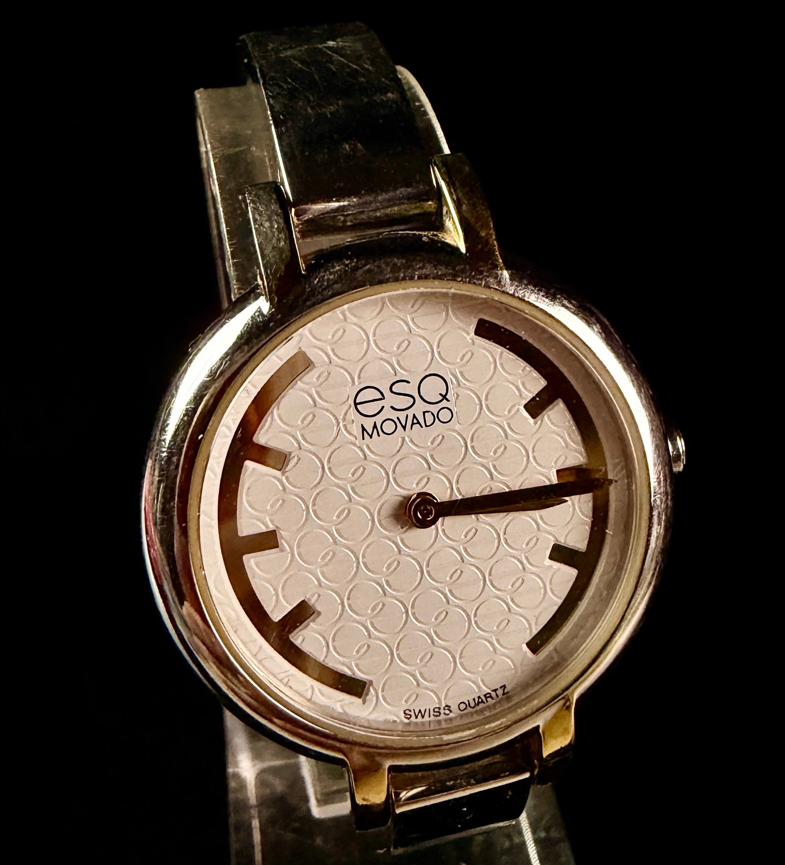 Ladies ESQ Movado Two-Tone Stainless Steel Bangle Watch ES.43.3.20.5638: A ladies wristwatch by ESQ Movado, reference number ES.43.3.20.5638. The timepiece features a two-tone stainless steel construction with gold-tone accents. The cream-colored dial is decorated with a r