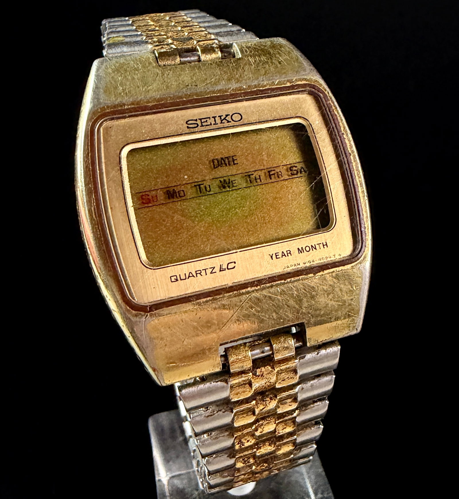 Seiko Quartz LC Digital Calendar Watch M154-4029: A vintage Seiko Quartz LC digital watch, model M154-4029. The timepiece features a gold-tone base metal top case with a stainless steel case back and an integrated two-tone bracelet in silver and