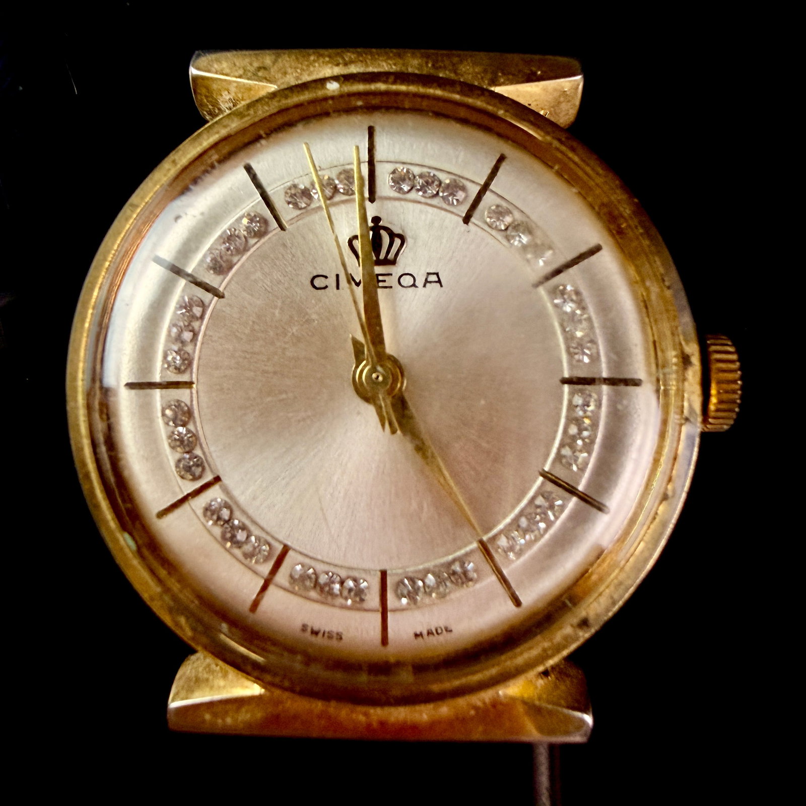 Vintage Cimeqa Swiss Made Manual Wind Wristwatch: A vintage manual wind wristwatch by Cimeqa. The timepiece features a round dial with a silver sunburst finish, decorated with an inner ring of inset clear crystal accents and applied golden baton hour