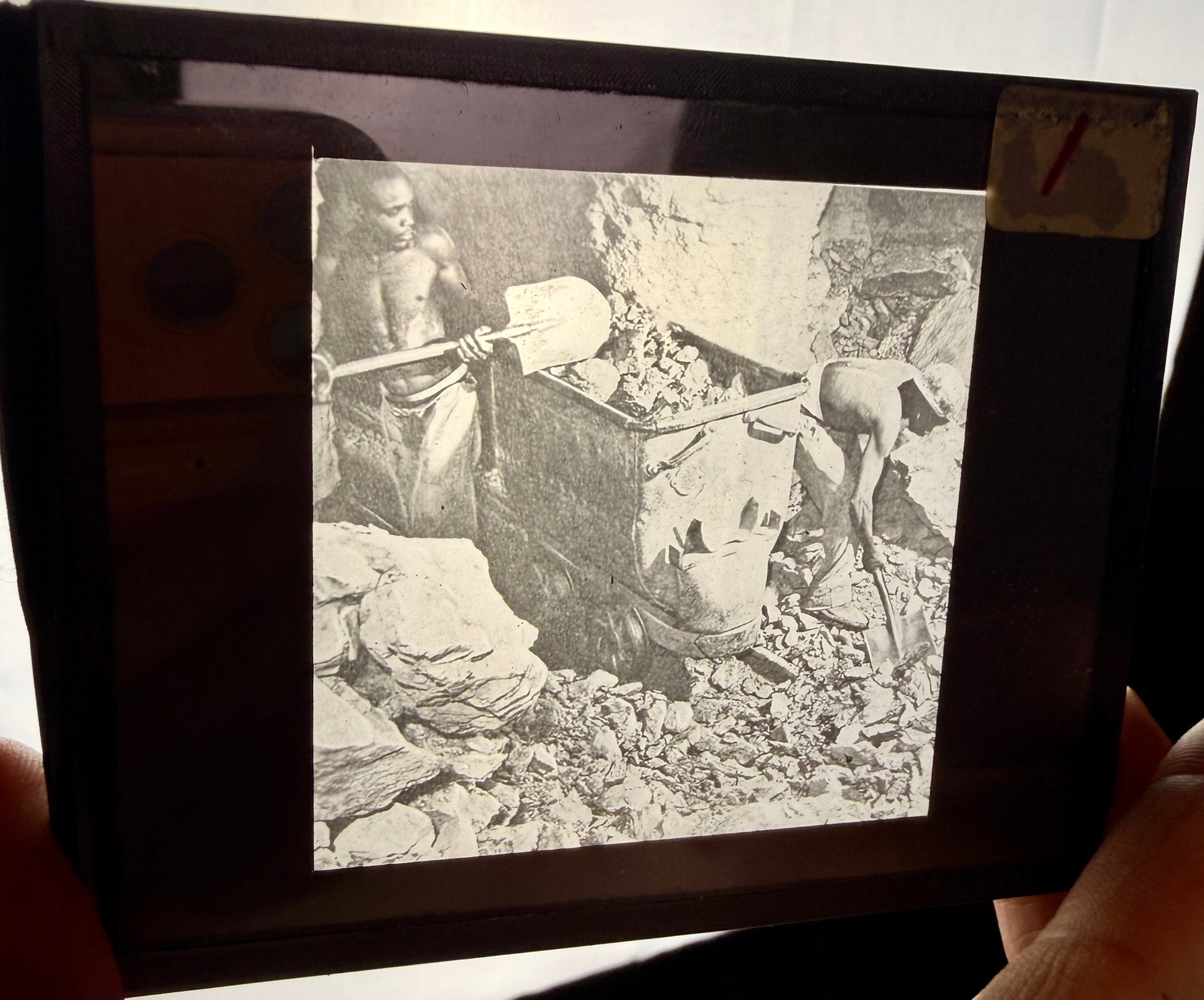 A Group of Four Industrial and Labor Silver Gelatin Lantern Slides: A collection of four silver gelatin lantern slides (glass plate positives) documenting various industrial and technical subjects. The images include a subterranean mining scene featuring two laborers 