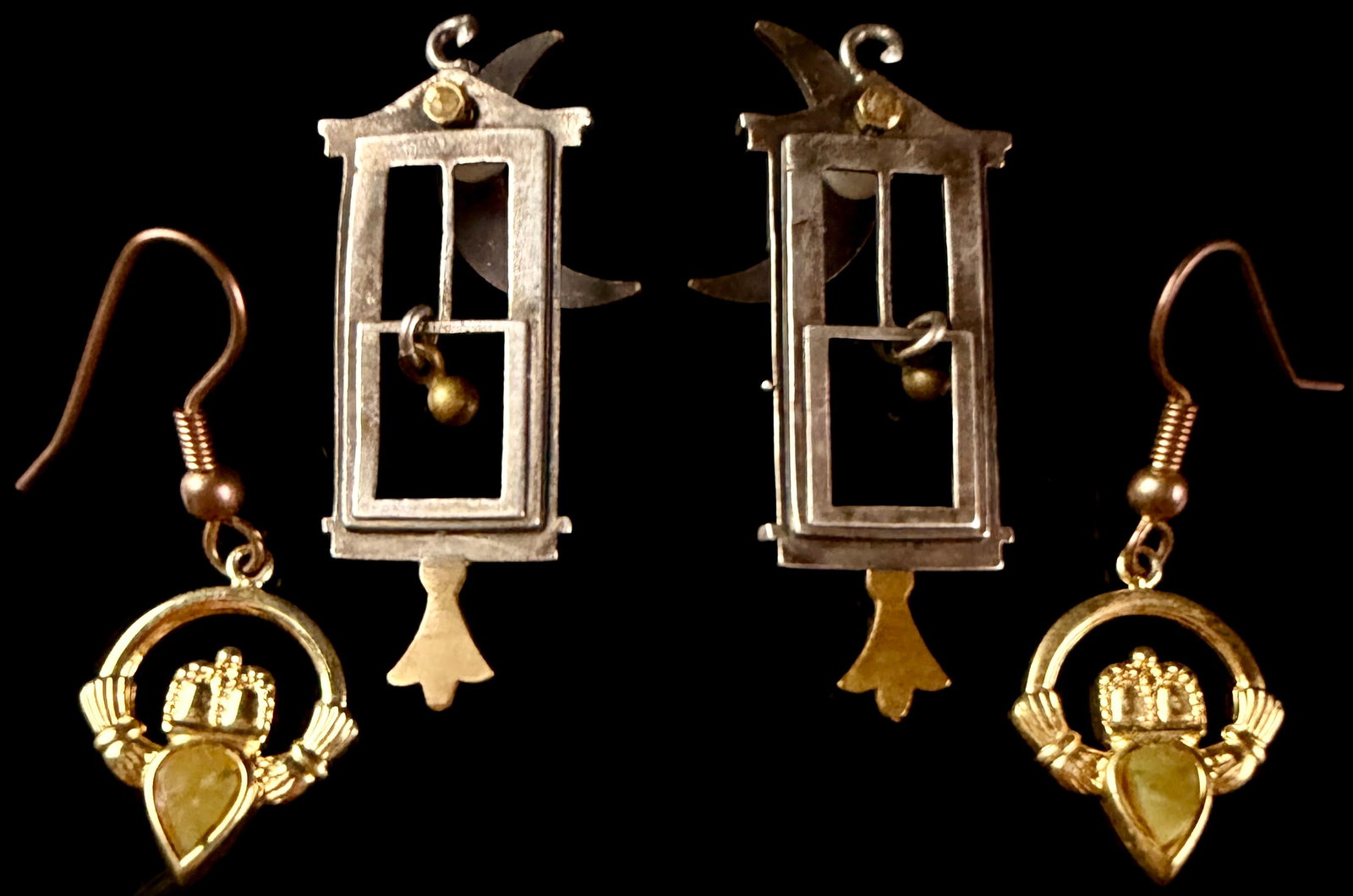 A Pair of Guillotine Motif Mixed-Metal Earrings and a Pair of Claddagh Motif Drop Earrings: This lot features two pairs of mixed-metal decorative earrings. The first pair consists of drop earrings featuring a guillotine motif, a design often associated with French Revolution historical repro