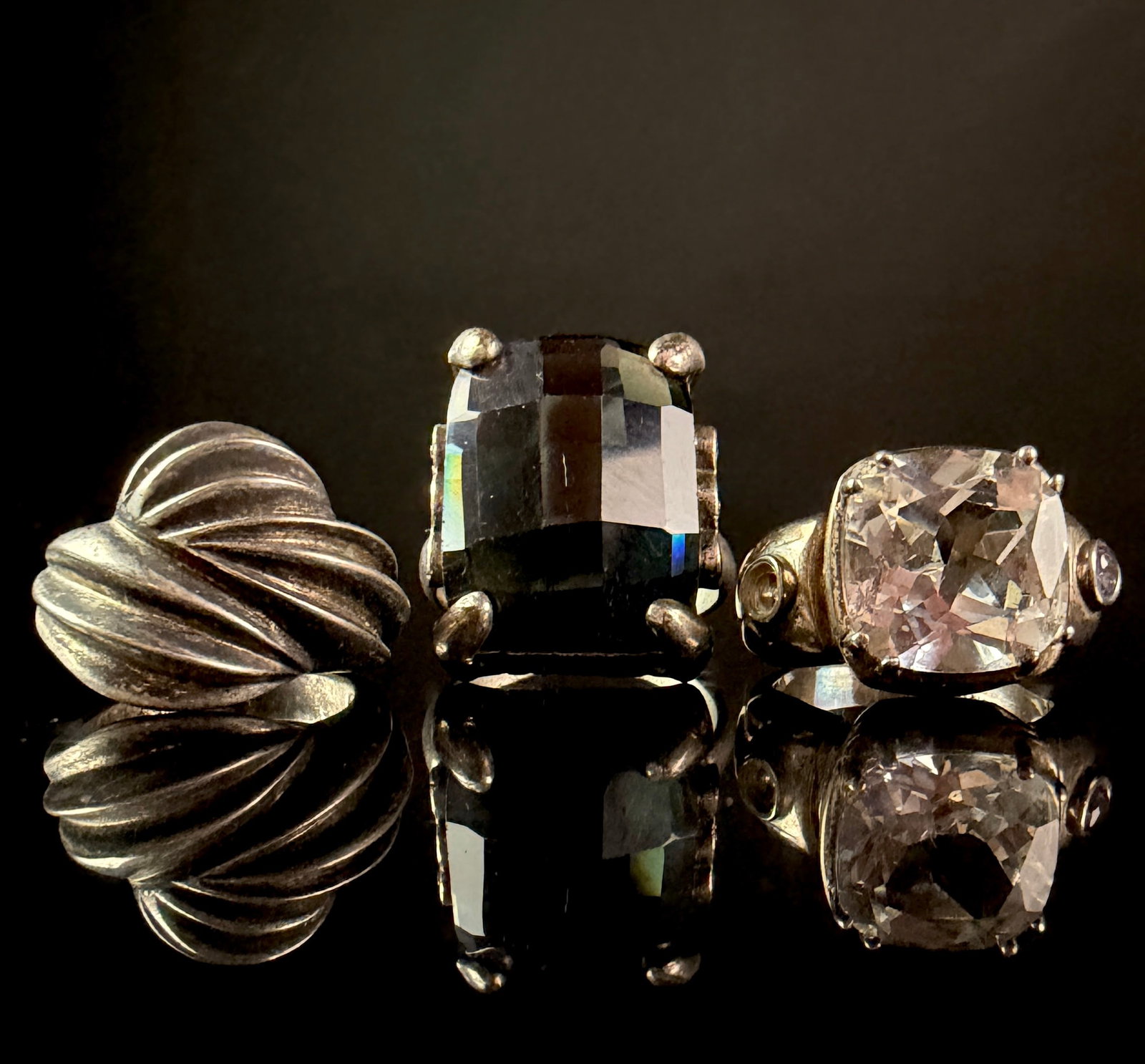 A Trio of Sterling Silver Cocktail Rings including a TOUS Swirl Dome Ring: A collection of three sterling silver cocktail rings in bold statement styles. The first ring is a high-profile dome ring by TOUS, featuring a textured swirl or twisted pattern throughout the head. Th