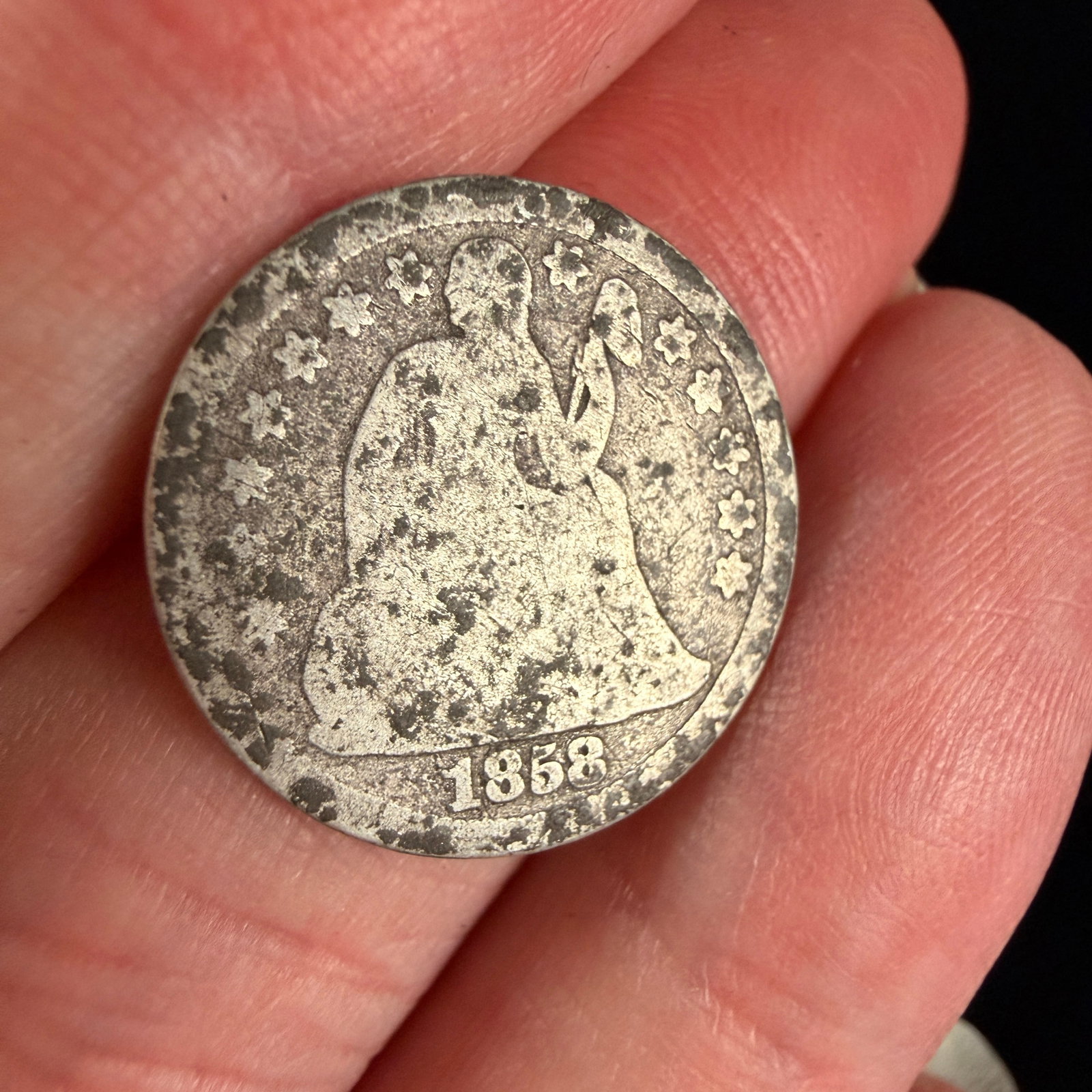 US 1858-O Seated Liberty Silver Dime: This United States Seated Liberty silver dime is dated 1858. The obverse depicts Liberty seated on a rock, holding a staff with a Phrygian cap and a shield, surrounded by thirteen stars. The date
