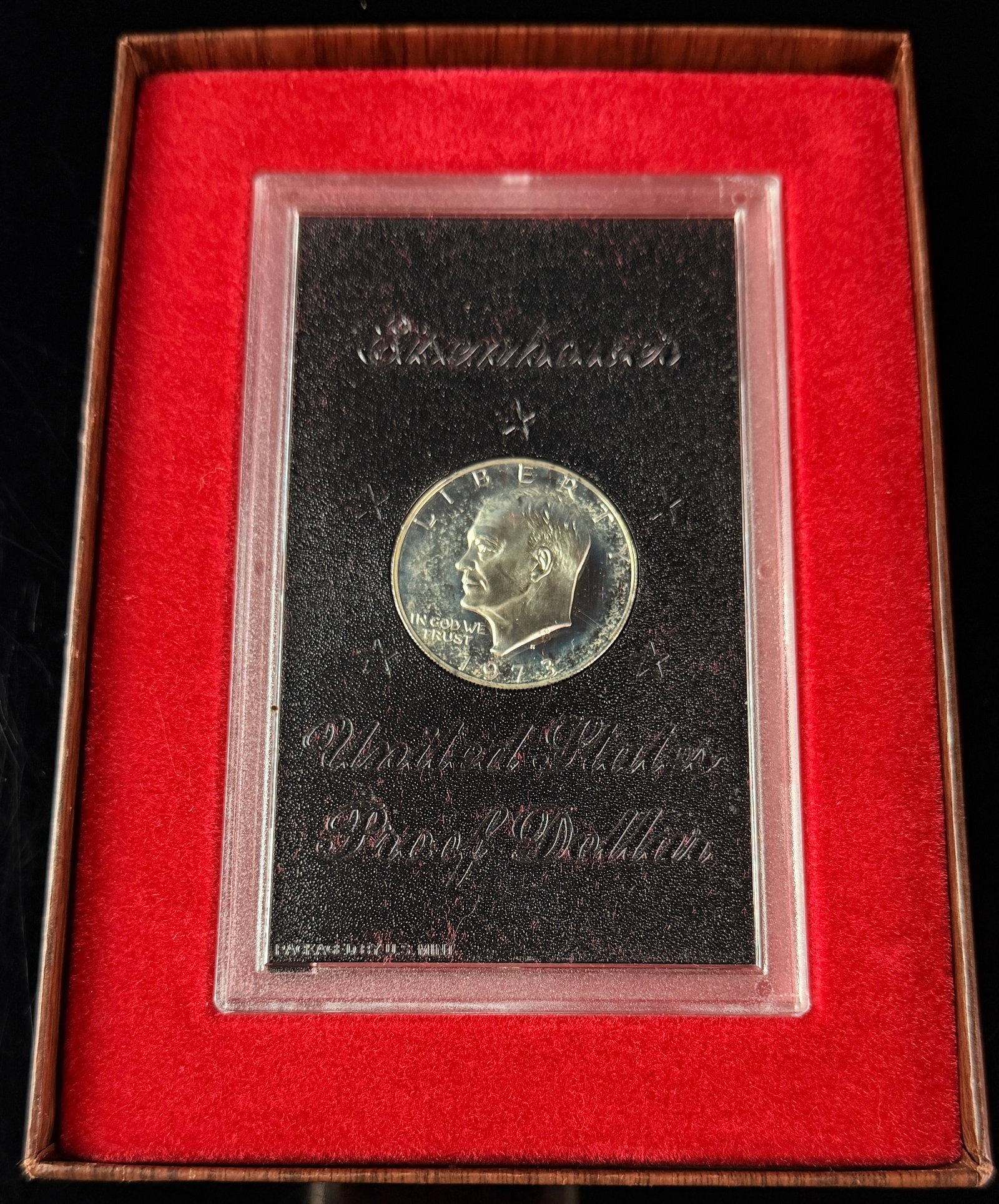 1973-S US Eisenhower 40% Silver Proof Dollar in Original Government Packaging: A 1973-S US Eisenhower proof dollar composed of 40% silver. The obverse features a profile portrait of Dwight D. Eisenhower with the inscriptions LIBERTY, IN GOD WE TRUST, and the date 1973. The mint 