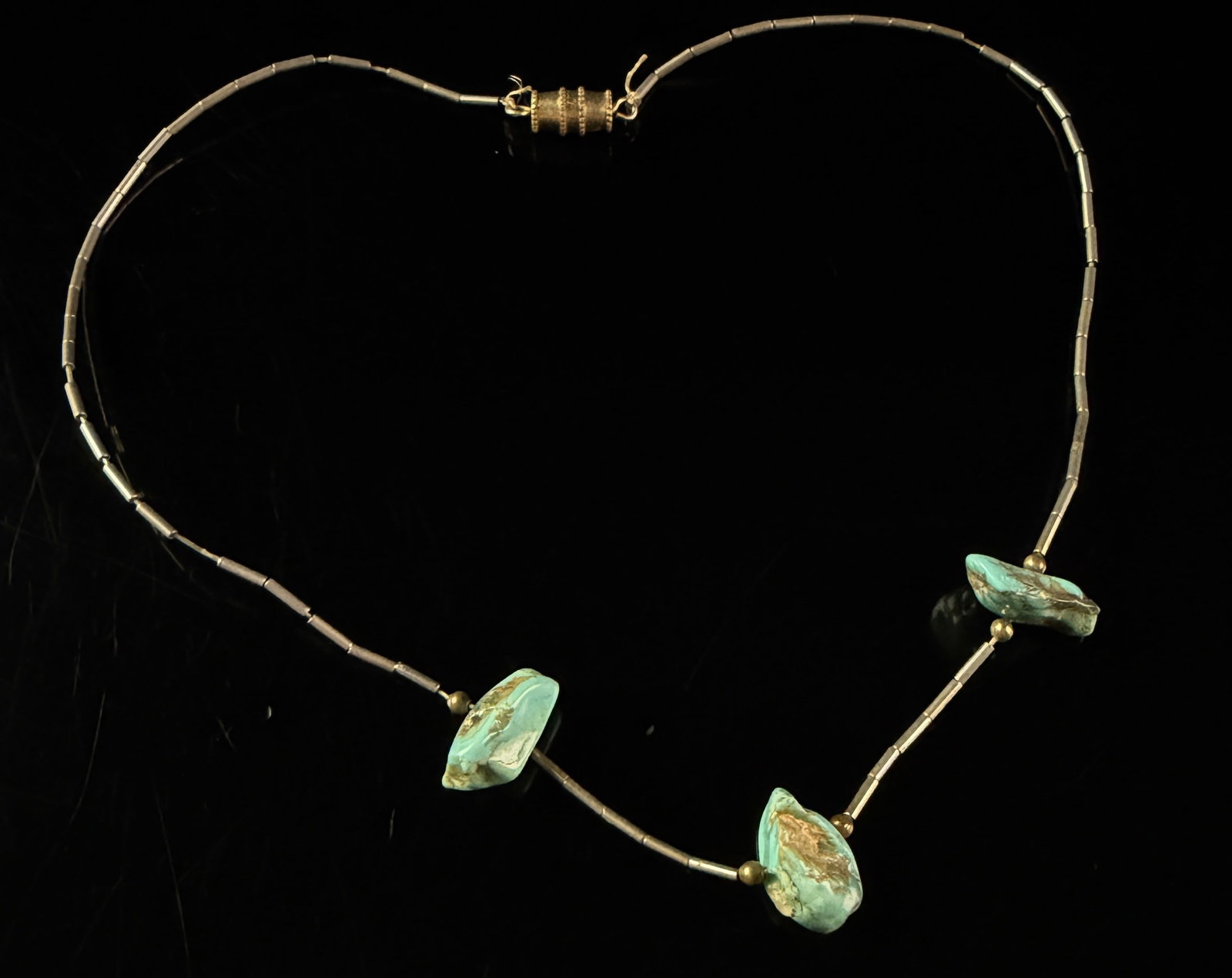 Vintage Liquid Silver and Turquoise Nugget Station Necklace: A vintage Southwestern-style station necklace constructed with fine silver-toned metal tubes in a liquid silver design. The necklace features three natural turquoise nuggets as central stations,