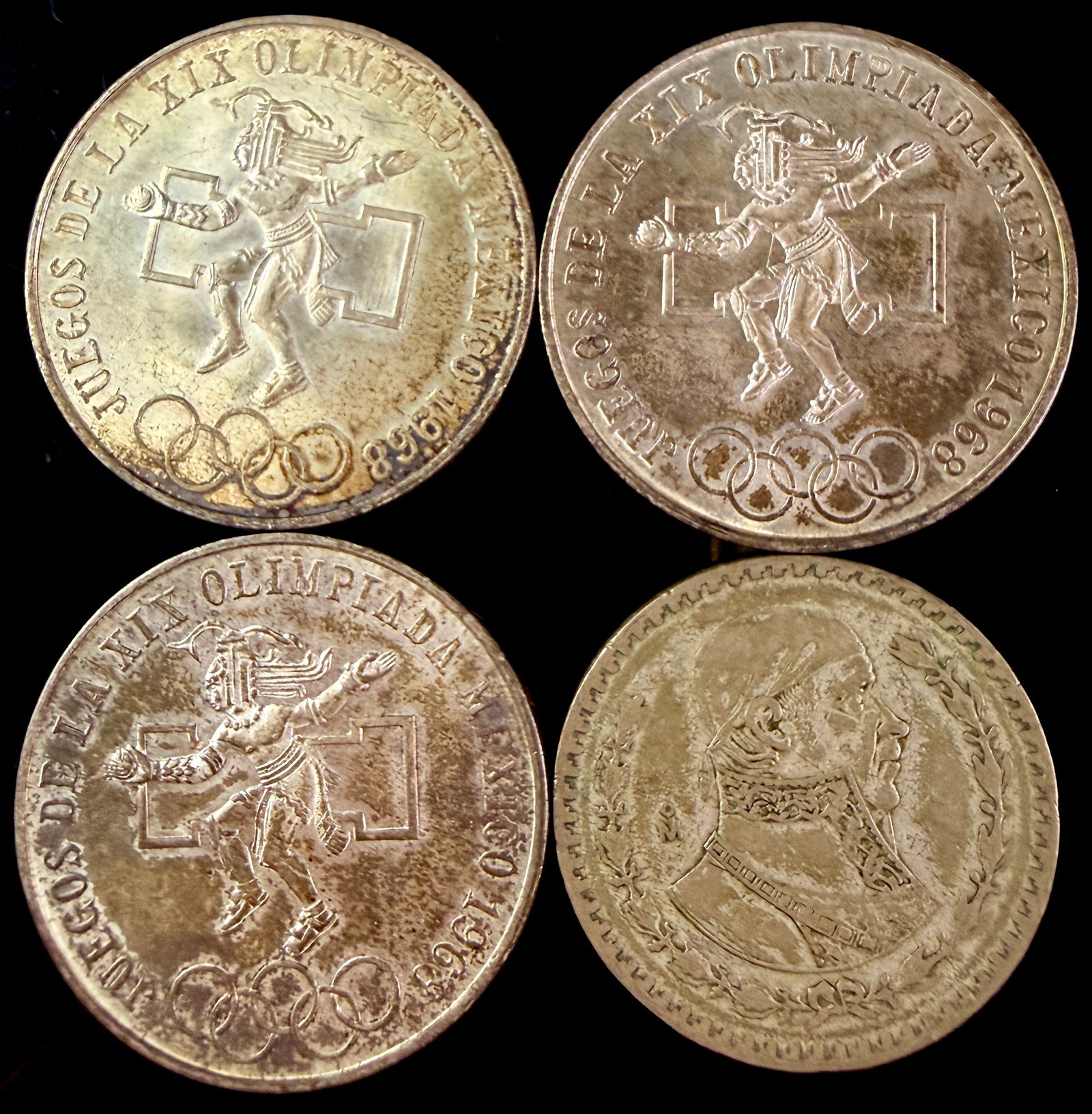 A Group of Four Mexican Silver Coins Including 1968 Olympic 25 Pesos and 1958 Un Peso Issues: A group of four vintage Mexican silver coins consisting of three commemorative 25 Pesos pieces and one 1958 Un Peso coin. The three 25 Pesos coins were issued for the Games of the XIX Olympiad in 1968