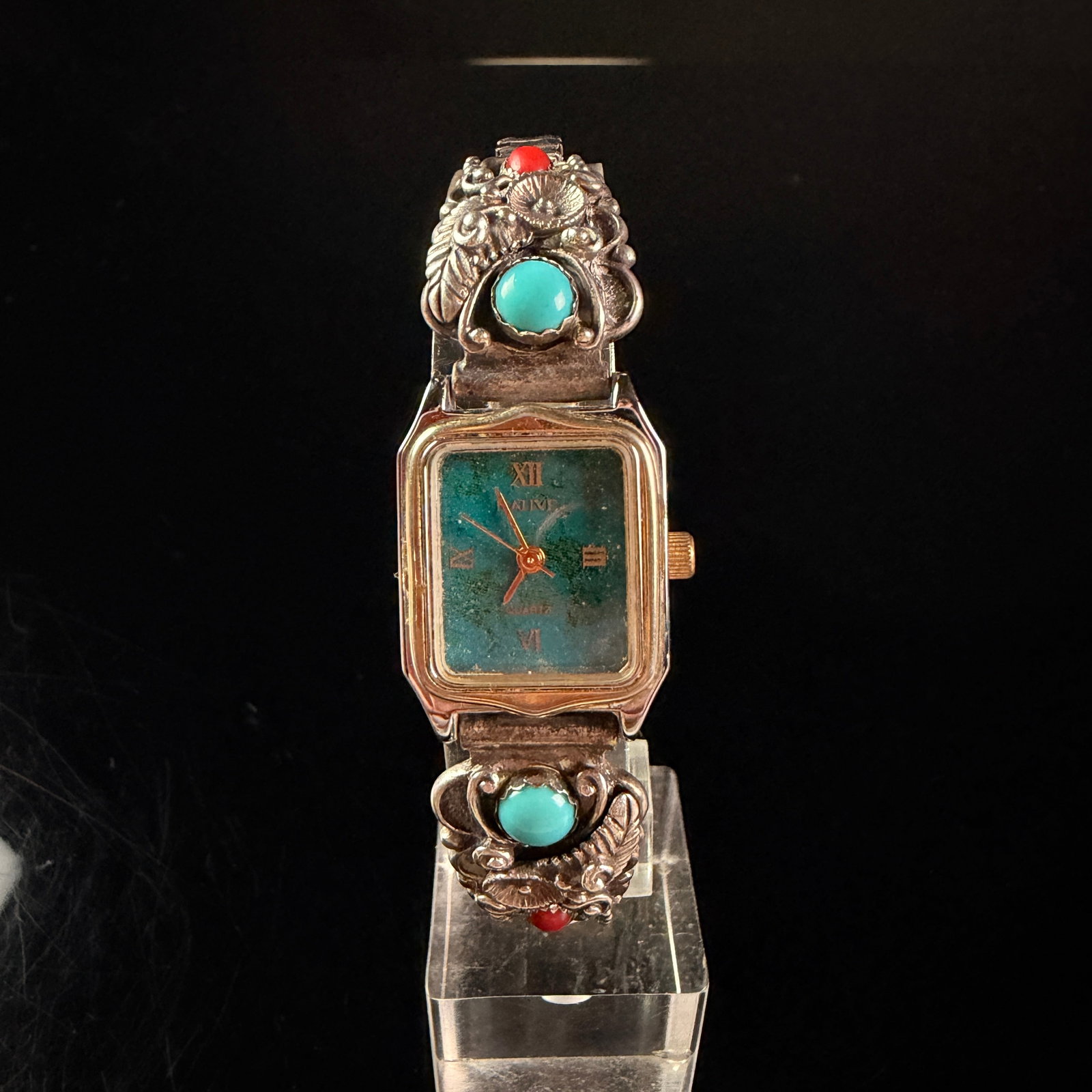 Sky Thunderbird Corporation Sterling Silver Ladies Native American Style Quartz Wristwatch: A ladies quartz wristwatch featuring a two-tone base metal case with a gold-tone bezel and a stainless steel case back. The dial features a marbled teal and green finish with gold-tone hands and