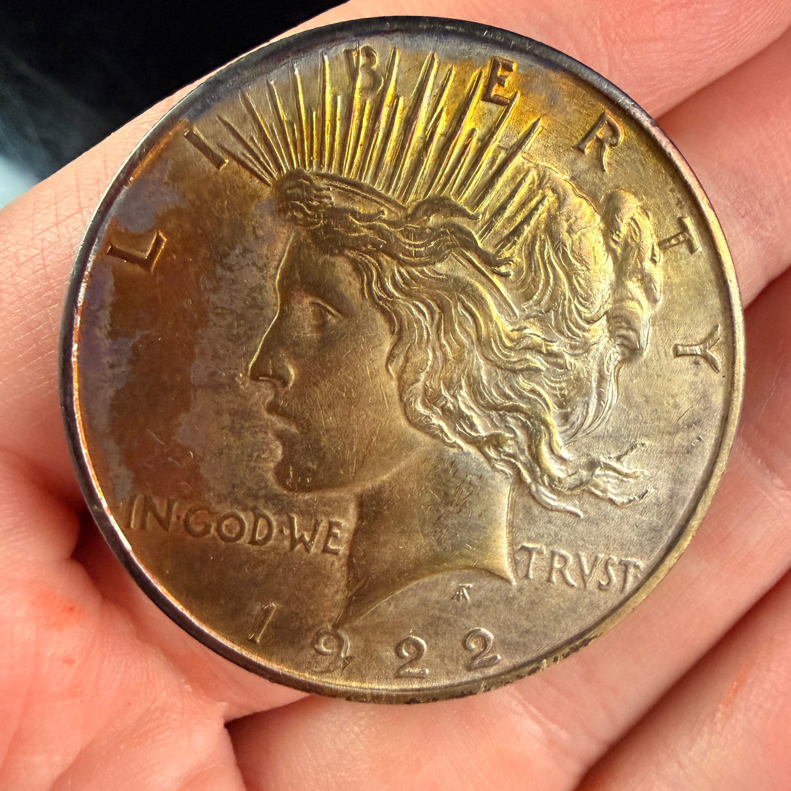 1922 US Peace Silver Dollar: A US Peace silver dollar minted in Philadelphia, composed of 0.900 fine silver. The obverse features the literal inscriptions LIBERTY along the upper rim, IN GOD WE TRVST across the center, and the da