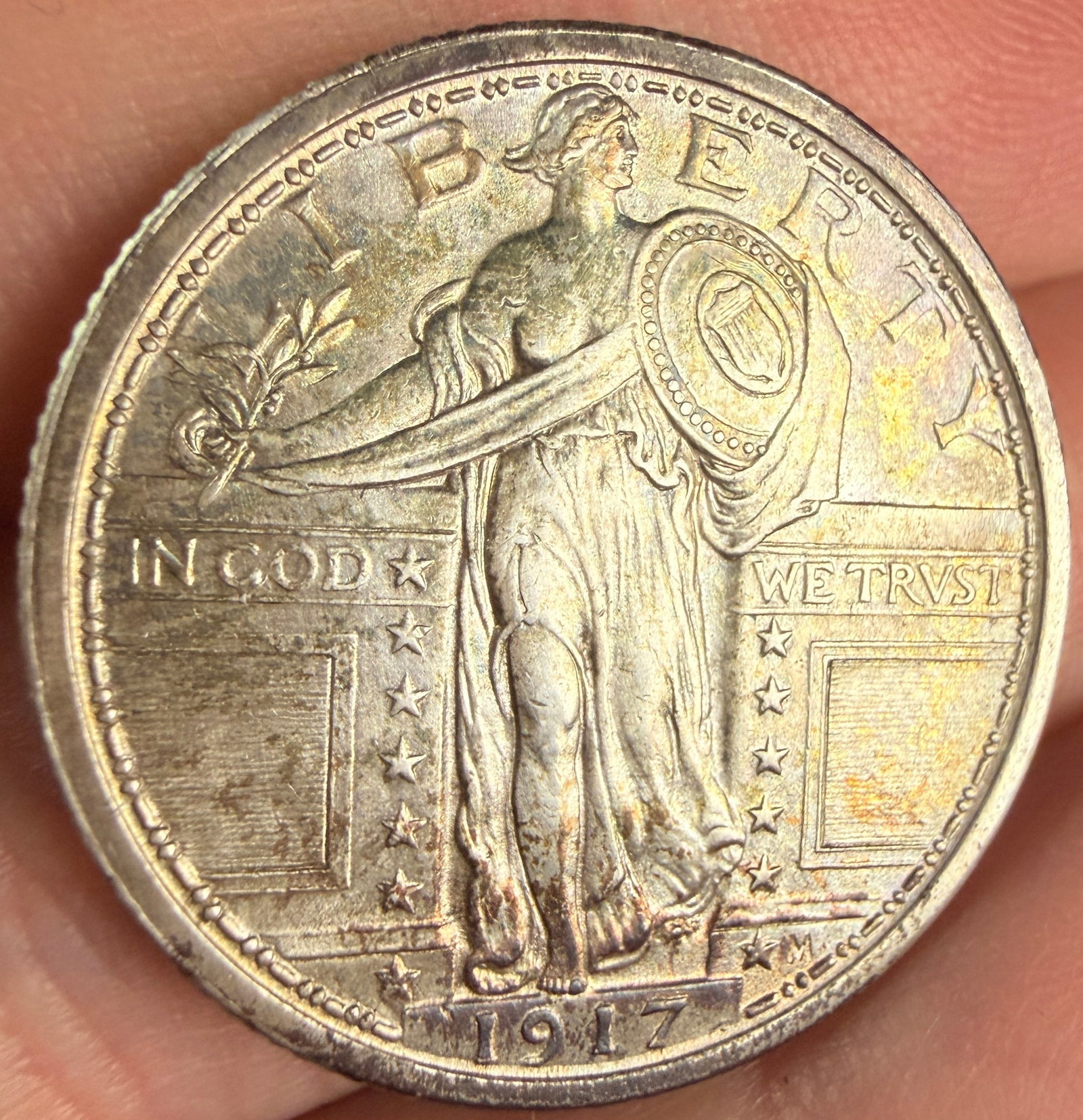 US 1917 Standing Liberty Silver Quarter, Type 1: This 1917 US silver Standing Liberty Quarter is a Type 1 variety, struck at the Philadelphia Mint. The composition is .900 fine silver and .100 copper. The obverse bears an impressed initial M to the 