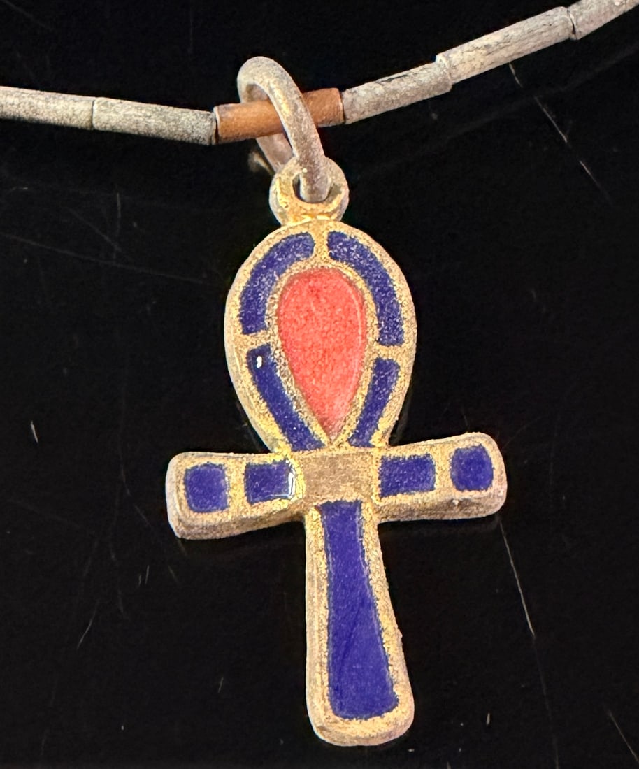 MMA 1976 Egyptian Revival Enamel and Turquoise-Color Bead Ankh Necklace: An Egyptian Revival necklace featuring a central ankh pendant and a multi-material beaded strand. The ankh pendant is constructed from gold-toned base metal with a recessed front face featuring red an